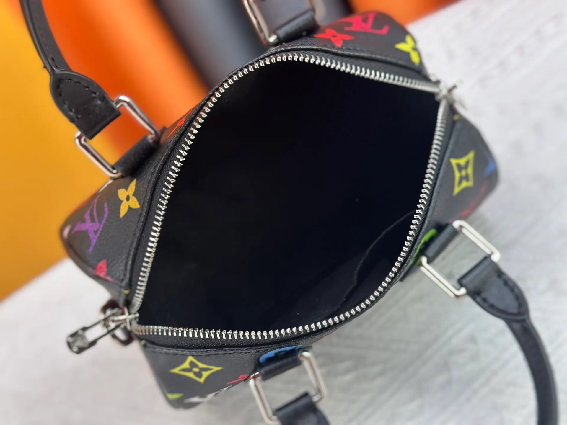 P260 Upgraded from the original version, this M46234 M46222 Speedy Bandoulière 20 handbag is made of soft coated canvas, with the full-length Monogram pattern traced in colorful rainbow tones, highlighting the smart style of the Louis Vuitton x Murakami reissue series. The Toron handle and detachable shoulder strap are constructed of cow leather, the metal corners recall classic luggage elements, and the bow-shaped key bag and padlock add brand touches. Dimensions: 20.5 x 13.5 x 12.0 cm (length x height x width)