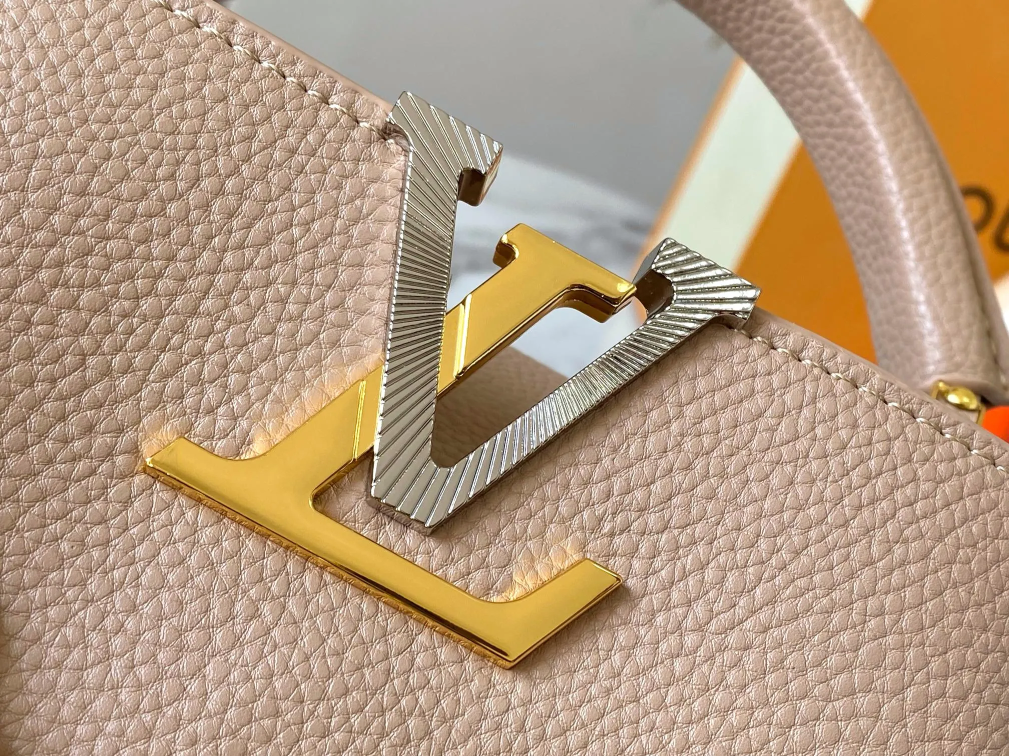 P480 [Guangzhou top quality original version] M26351 apricot color. This modern version of the Capucines mini is made of timeless Taurillon leather and equipped with a jewelry-inspired Infinity chain. The bag is decorated with double galvanized metal parts, including the iconic Monogram floral pattern, and the LV Initials logo created with sunburst technology, creating a sundial-like light and shadow effect. The bag has multiple pockets and a detachable shoulder strap, allowing it to be carried on one shoulder or across the body. 14 x 8 x 21 cm (height x width x length)