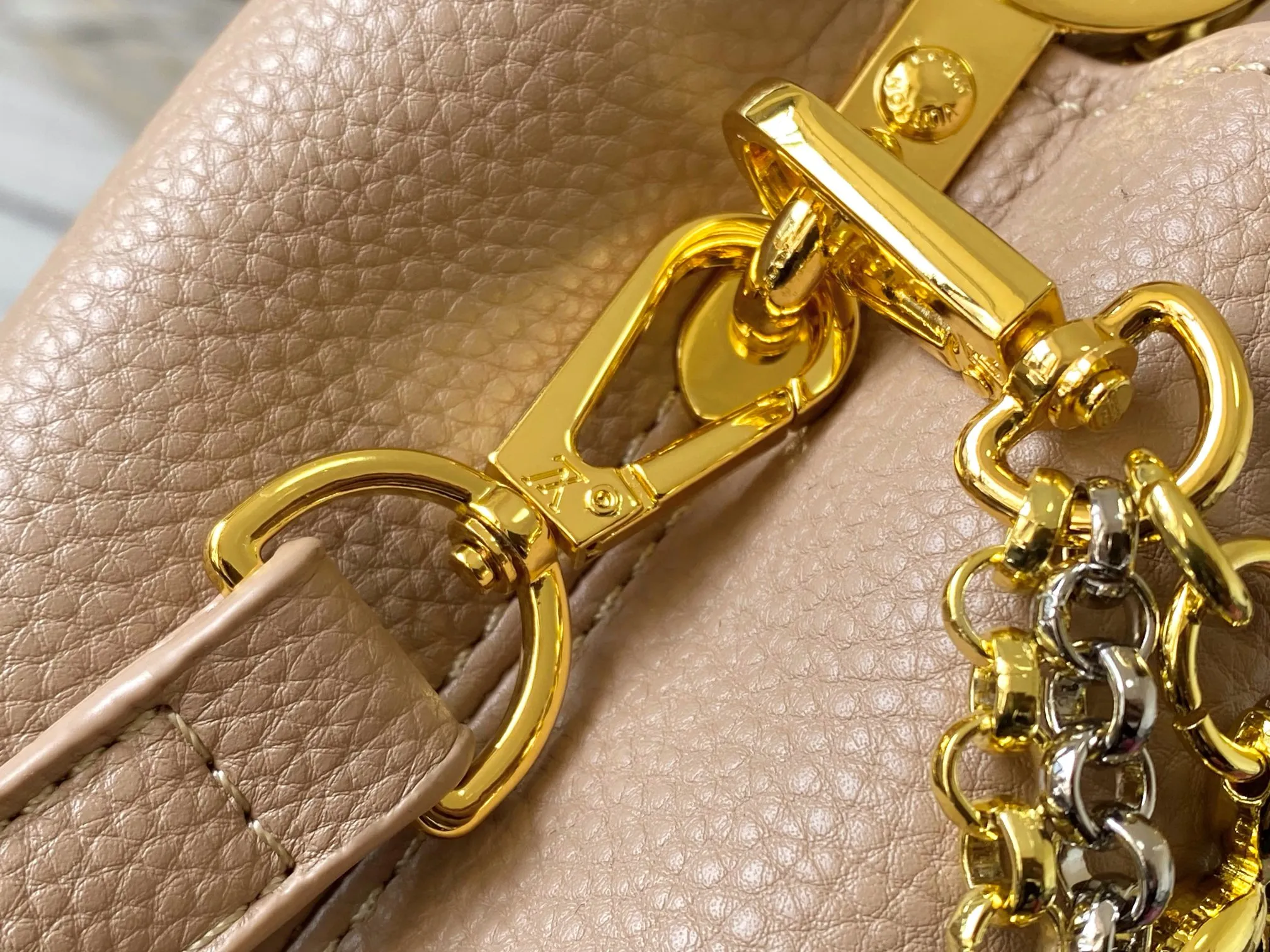 P480 [Guangzhou top quality original version] M26351 apricot color. This modern version of the Capucines mini is made of timeless Taurillon leather and equipped with a jewelry-inspired Infinity chain. The bag is decorated with double galvanized metal parts, including the iconic Monogram floral pattern, and the LV Initials logo created with sunburst technology, creating a sundial-like light and shadow effect. The bag has multiple pockets and a detachable shoulder strap, allowing it to be carried on one shoulder or across the body. 14 x 8 x 21 cm (height x width x length)