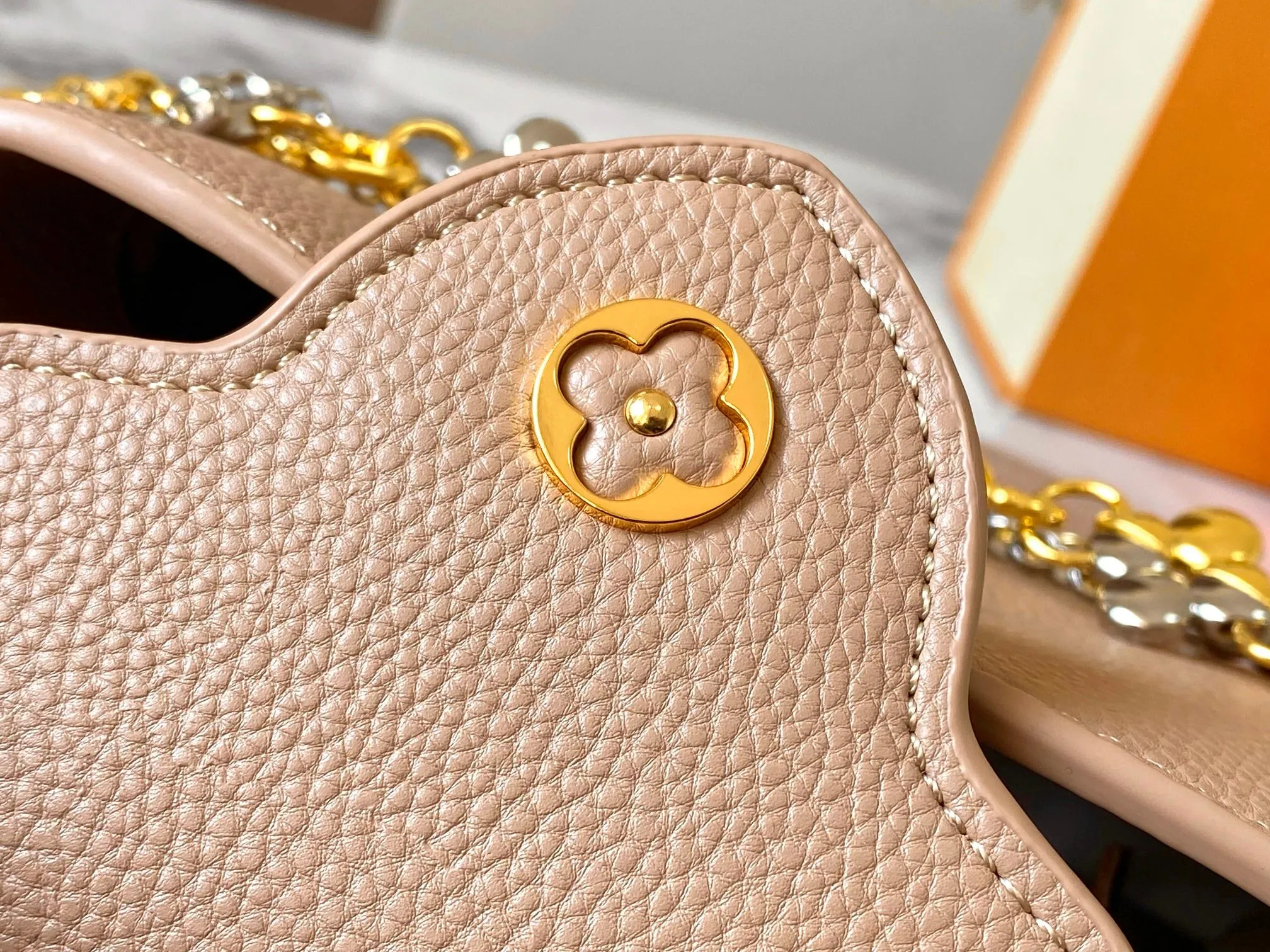 P480 [Guangzhou top quality original version] M26351 apricot color. This modern version of the Capucines mini is made of timeless Taurillon leather and equipped with a jewelry-inspired Infinity chain. The bag is decorated with double galvanized metal parts, including the iconic Monogram floral pattern, and the LV Initials logo created with sunburst technology, creating a sundial-like light and shadow effect. The bag has multiple pockets and a detachable shoulder strap, allowing it to be carried on one shoulder or across the body. 14 x 8 x 21 cm (height x width x length)