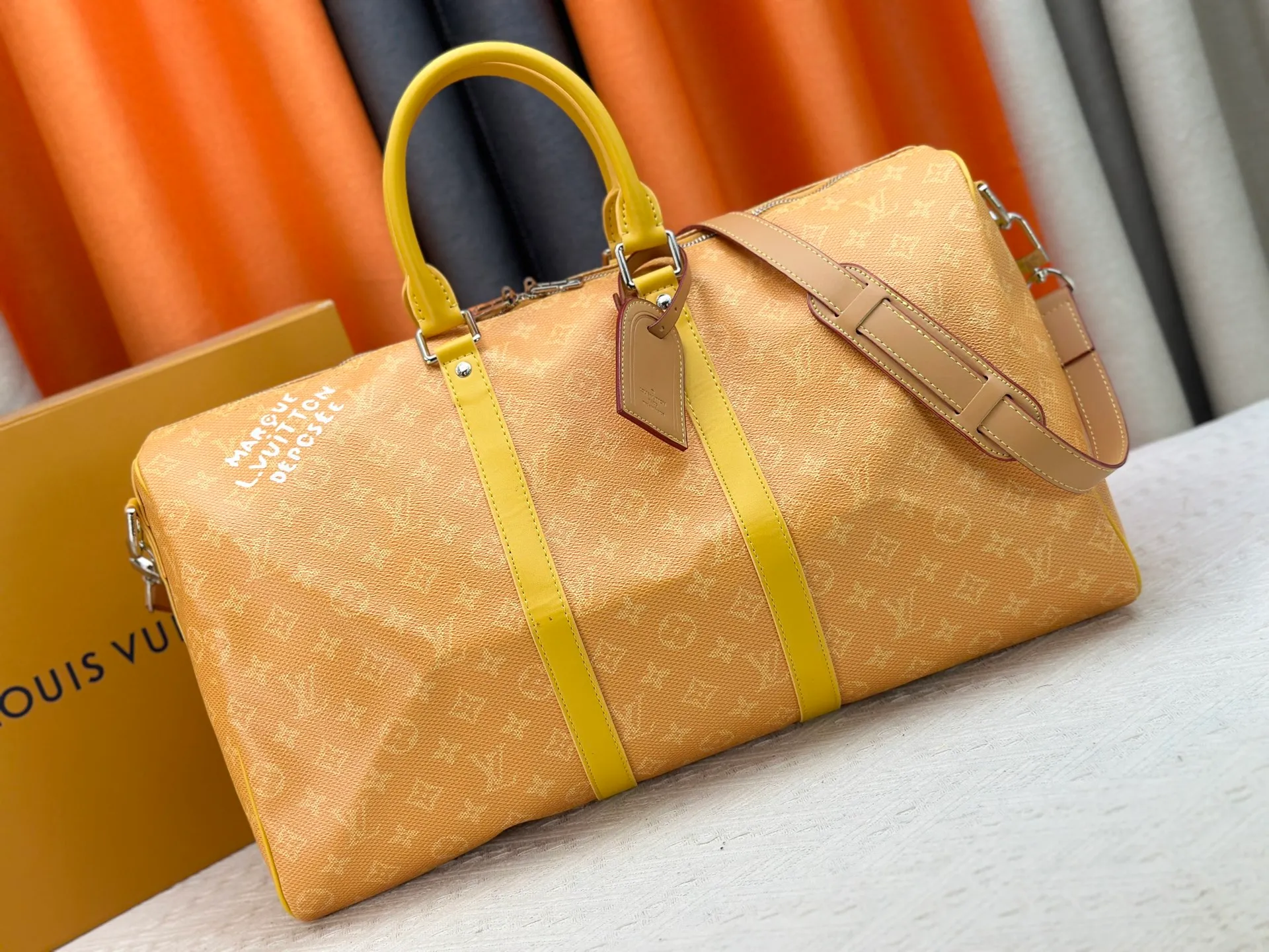 P340 Upgraded original M26864 M26865 M26866 This Keepall Bandoulière 50 travel bag is made of Monogram Heritage canvas dip-dyed in colorful colors, with cowhide trim, leather shoulder straps, removable leather nameplate and cotton lining. The Marque L.Vuitton Déposée logo pays homage to Louis Vuitton’s rich heritage.  29 x 23 x 50 cm (H x W x L) Monogram Heritage coated canvas Cow leather trim Textile lining Metal hardware Carry-on baggage dimensions Double zip closure Padlock Removable name tag Internal zip pocket Handles: Double handles