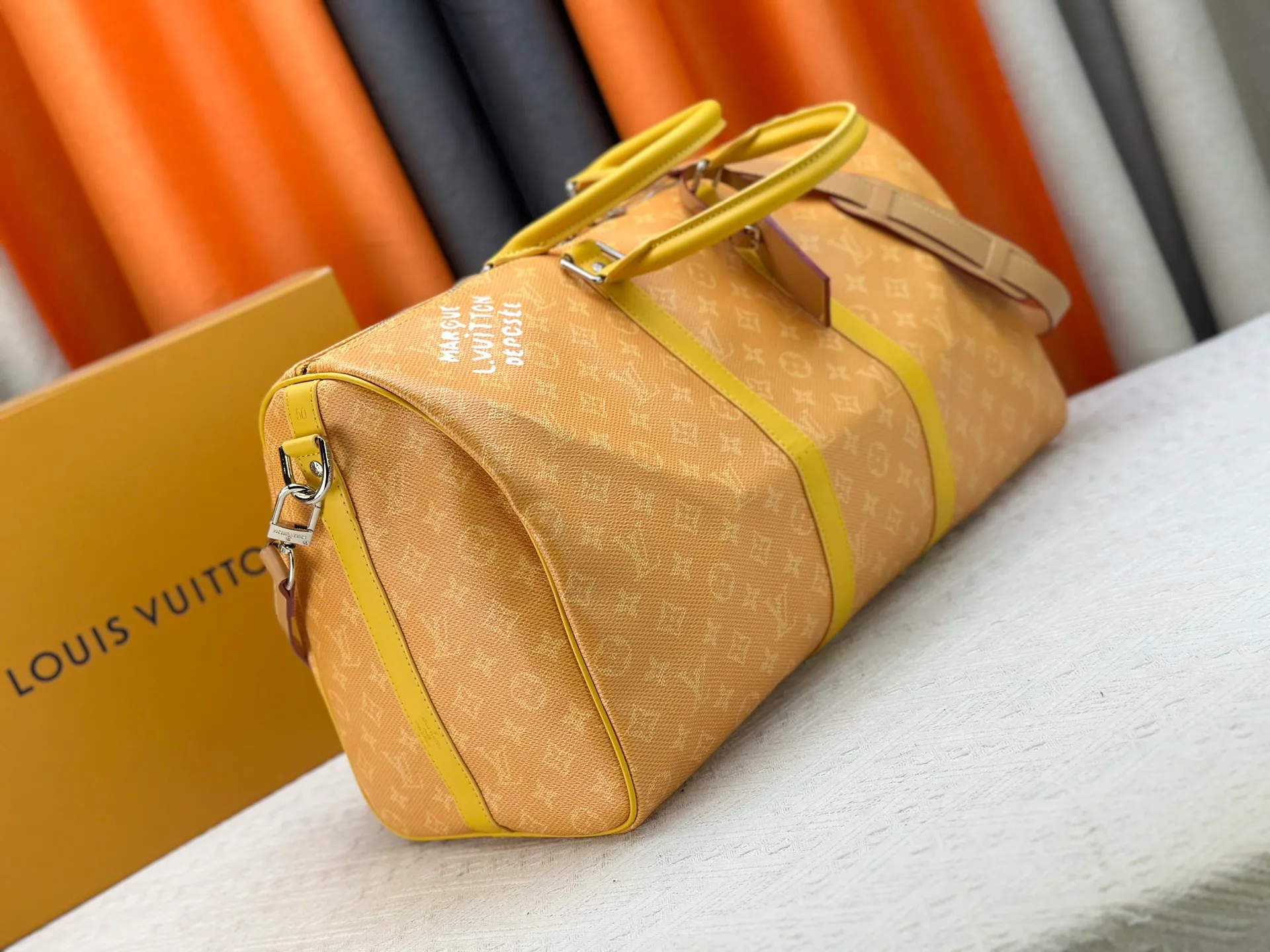 P340 Upgraded original M26864 M26865 M26866 This Keepall Bandoulière 50 travel bag is made of Monogram Heritage canvas dip-dyed in colorful colors, with cowhide trim, leather shoulder straps, removable leather nameplate and cotton lining. The Marque L.Vuitton Déposée logo pays homage to Louis Vuitton’s rich heritage.  29 x 23 x 50 cm (H x W x L) Monogram Heritage coated canvas Cow leather trim Textile lining Metal hardware Carry-on baggage dimensions Double zip closure Padlock Removable name tag Internal zip pocket Handles: Double handles