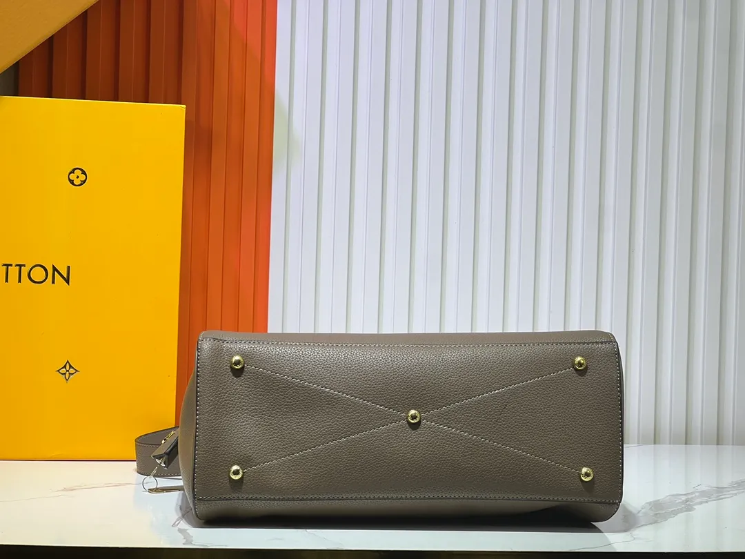 Batch 340💰M11214 green M22914 black M22925 brown M23061 off-white M22927 taupe. Sophisticated and functional, the Lock It MM bag is crafted in fine grained Taurillon leather and smooth calfskin, with gold-finish buckles and hardware. Signature House touches include padlocks, key bells and hot-stamped Louis Vuitton signatures. Featuring an articulated top handle and removable strap, this tote offers a variety of carrying options. 36x29x15 cm (LxHxW) Black Taurillon leather, smooth calfskin semi-leather trim Microfiber lining Gold hardware 2 square buckles padlock key bell External pockets 2 internal flat pockets Internal zipped pocket with flat pockets 5 protective metal studs Strap: removable, adjustable Strap drop: 45.0 cm Maximum strap drop: 51.0 cm