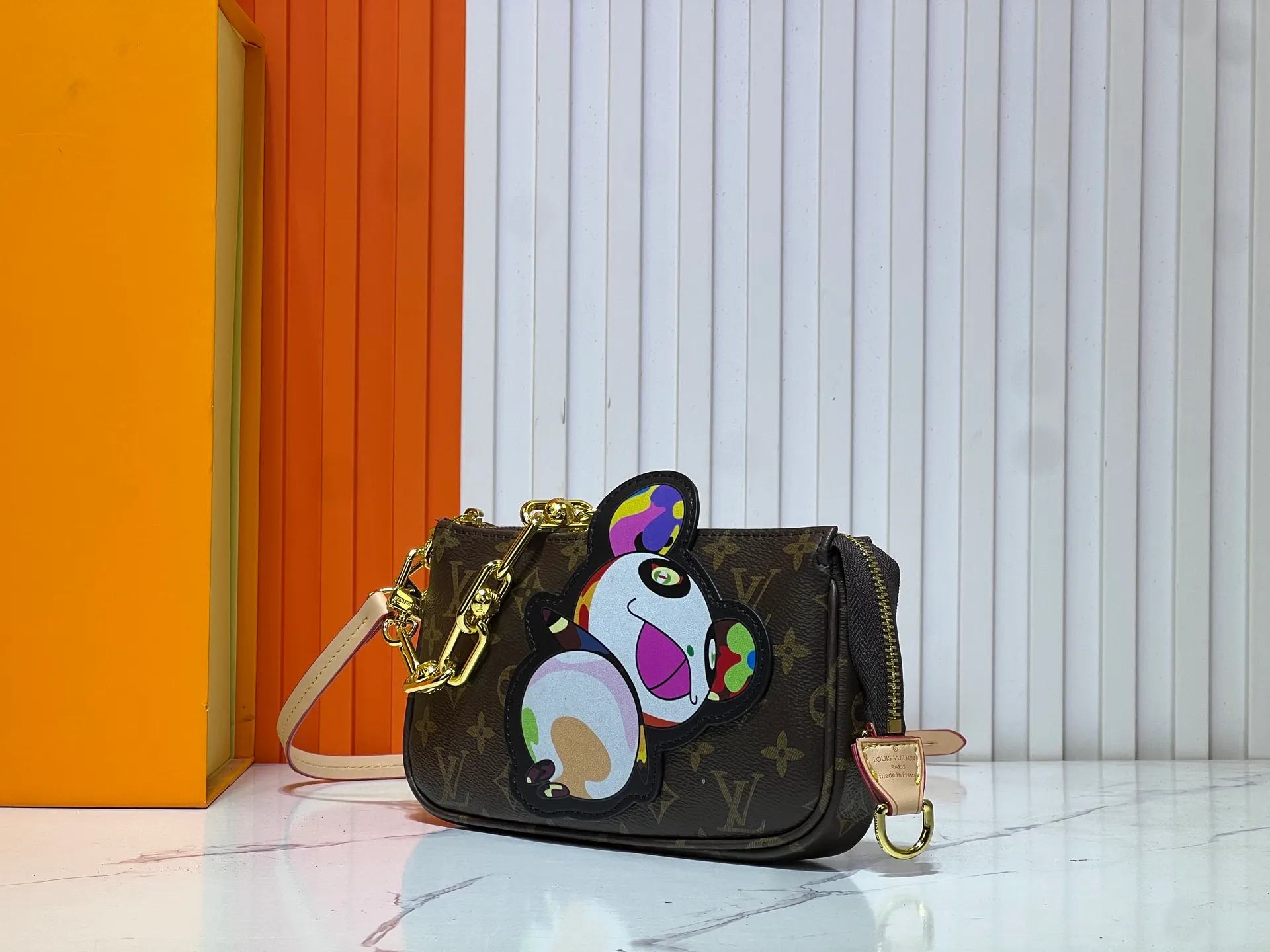 Batch 240💰M13440 This Pochette Accessoires handbag is made of Monogram coated canvas, injecting lively personality into the Louis Vuitton x Murakami reissue series. The colorful panda image created by the artist renews the classic silhouette, and the zipper design allows for secure storage of daily items. The cowhide leather shoulder strap and dazzling chain are both detachable, allowing for a variety of carrying options. Size: 22X13X4cm