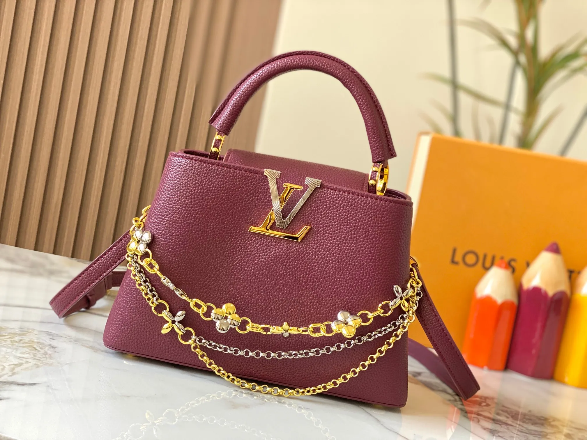 P500 [Guangzhou top quality original version] M26532 Bordeaux Red This modern version of Capucines BB is made of timeless Taurillon leather and equipped with a jewelry-inspired Infinity chain. The bag is decorated with double galvanized metal parts, including the iconic Monogram floral pattern, and the LV Initials logo created with sunburst technology, creating a sundial-like light and shadow effect. The bag has multiple pockets and a detachable shoulder strap, allowing it to be carried on one shoulder or across the body. 27 x 17.3 x 9 (cm) (length x height x width)