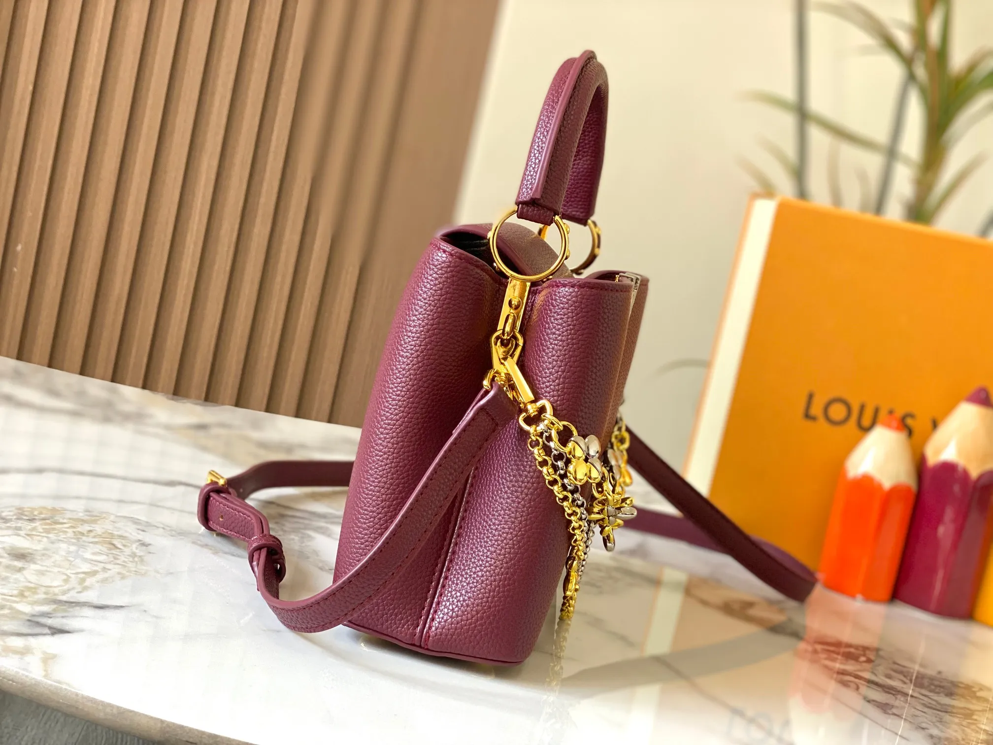 P500 [Guangzhou top quality original version] M26532 Bordeaux Red This modern version of Capucines BB is made of timeless Taurillon leather and equipped with a jewelry-inspired Infinity chain. The bag is decorated with double galvanized metal parts, including the iconic Monogram floral pattern, and the LV Initials logo created with sunburst technology, creating a sundial-like light and shadow effect. The bag has multiple pockets and a detachable shoulder strap, allowing it to be carried on one shoulder or across the body. 27 x 17.3 x 9 (cm) (length x height x width)