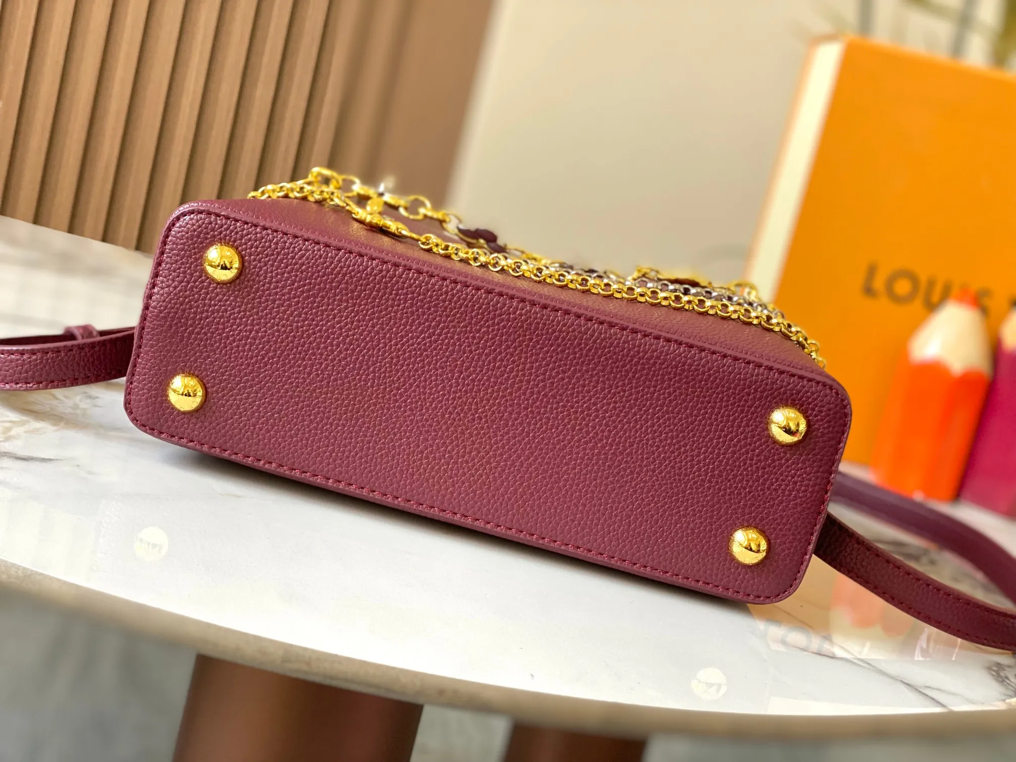 P500 [Guangzhou top quality original version] M26532 Bordeaux Red This modern version of Capucines BB is made of timeless Taurillon leather and equipped with a jewelry-inspired Infinity chain. The bag is decorated with double galvanized metal parts, including the iconic Monogram floral pattern, and the LV Initials logo created with sunburst technology, creating a sundial-like light and shadow effect. The bag has multiple pockets and a detachable shoulder strap, allowing it to be carried on one shoulder or across the body. 27 x 17.3 x 9 (cm) (length x height x width)