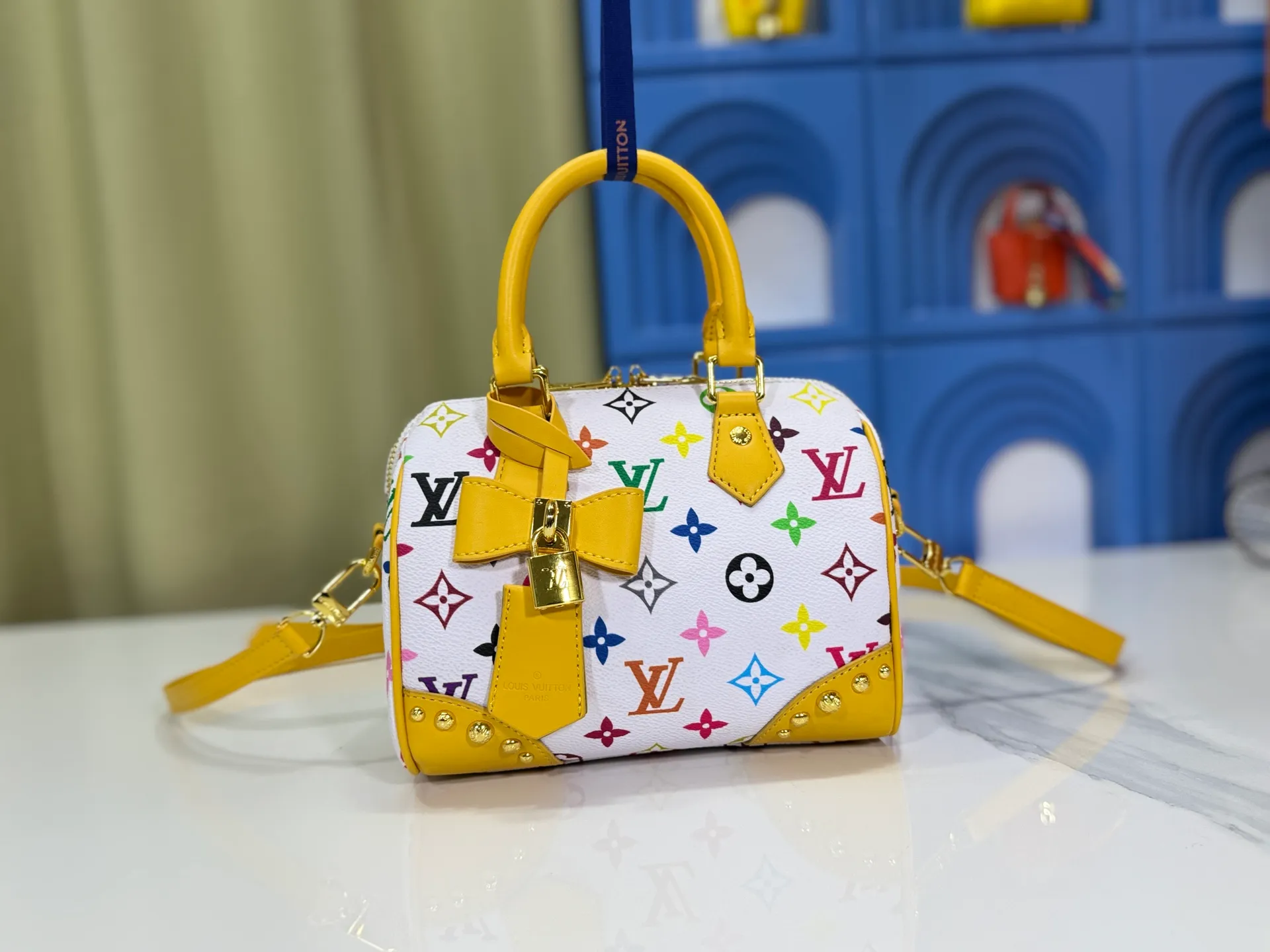 P280 upgraded original M58953 M46234 M46222 Speedy Bandoulière 20 handbag is made of soft coated canvas, and the full-length Monogram pattern is traced in colorful rainbow tones, highlighting the smart style of the Louis Vuitton x Murakami reissue series. The Toron handle and detachable shoulder strap are constructed of cow leather, the metal corners recall classic luggage elements, and the bow-shaped key bag and padlock add brand touches. Dimensions: 20.5 x 13.5 x 12.0 cm (length x height x width)