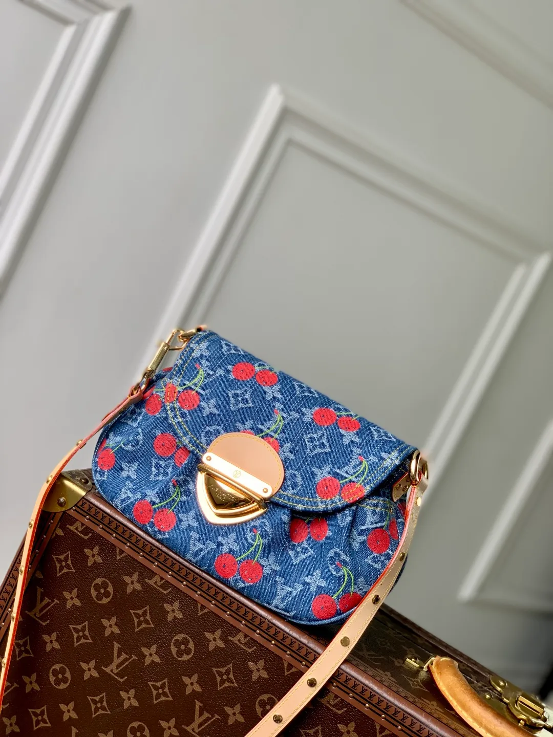 💰1180 Top quality original M13680 cherry. This Sunset handbag is cut in a retro silhouette, exuding a calm and elegant atmosphere. The thick rounded edges perfectly match the large golden plug-in lock. The handbag is made of Monogram denim, embellished with a playful and bright cherry embroidery pattern, taken from the charming replica Louis Vuitton x Murakami series, and has a studded natural leather shoulder strap, reflecting the brand's classic style. 27 x 18 x 3 cm (length x height x width)