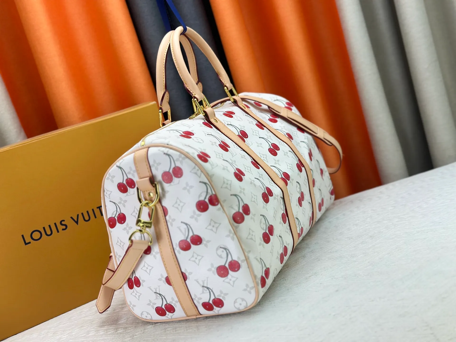 P340 Upgraded original [Keepall Bandoulière 45] M13764 white cherry travel bag has a new look from the Louis Vuitton x Takashi Murakami series. Classic Monogram canvas features a patchwork pattern of sweet cherries and a bold lining that reflects the playful aesthetic of renowned Japanese artist Takashi Murakami. Side straps, top handles and adjustable shoulder straps reveal the natural color of the leather, while dazzling hardware completes the look. Dimensions: 27 x 20 x 45 cm