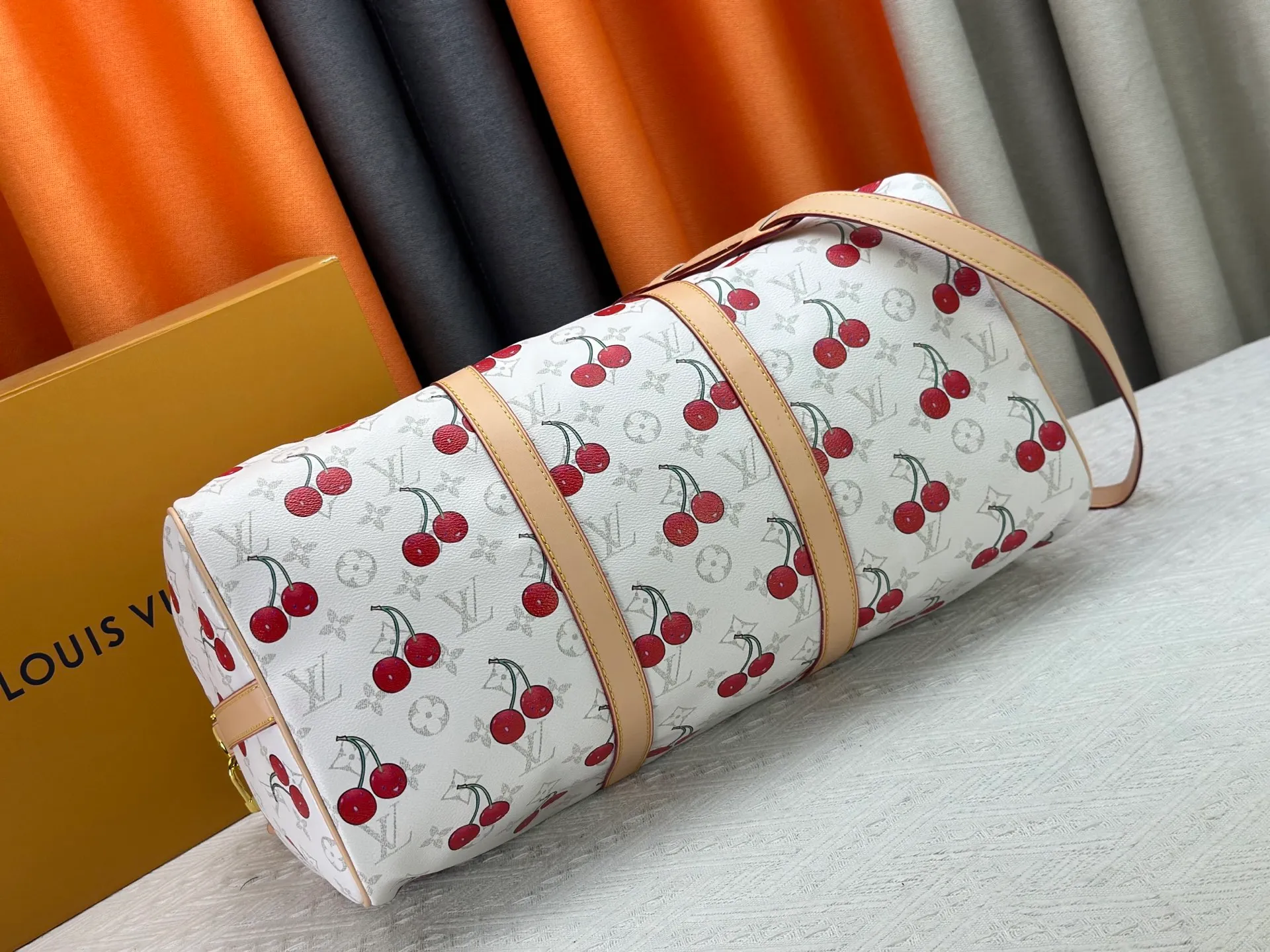 P340 Upgraded original [Keepall Bandoulière 45] M13764 white cherry travel bag has a new look from the Louis Vuitton x Takashi Murakami series. Classic Monogram canvas features a patchwork pattern of sweet cherries and a bold lining that reflects the playful aesthetic of renowned Japanese artist Takashi Murakami. Side straps, top handles and adjustable shoulder straps reveal the natural color of the leather, while dazzling hardware completes the look. Dimensions: 27 x 20 x 45 cm
