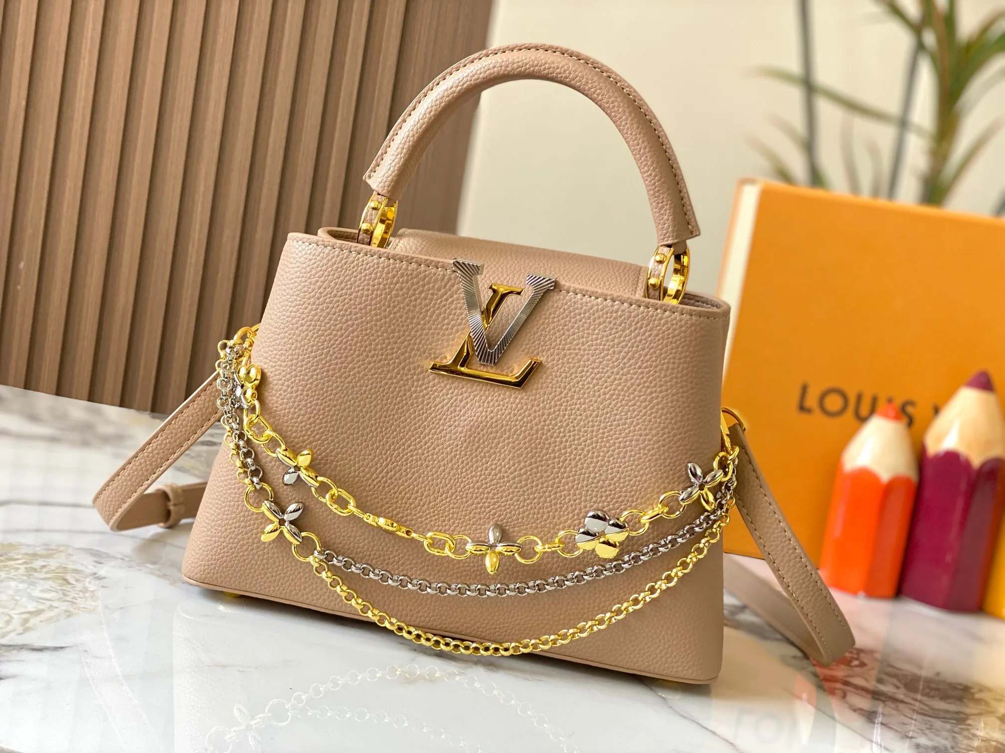 P500 [Guangzhou top quality original version] M26532 apricot color. This modern version of Capucines BB is made of timeless Taurillon leather and equipped with a jewelry-inspired Infinity chain. The bag is decorated with double galvanized metal parts, including the iconic Monogram floral pattern, and the LV Initials logo created with sunburst technology, creating a sundial-like light and shadow effect. The bag has multiple pockets and a detachable shoulder strap, allowing it to be carried on one shoulder or across the body. 27 x 17.3 x 9 (cm) (length x height x width)