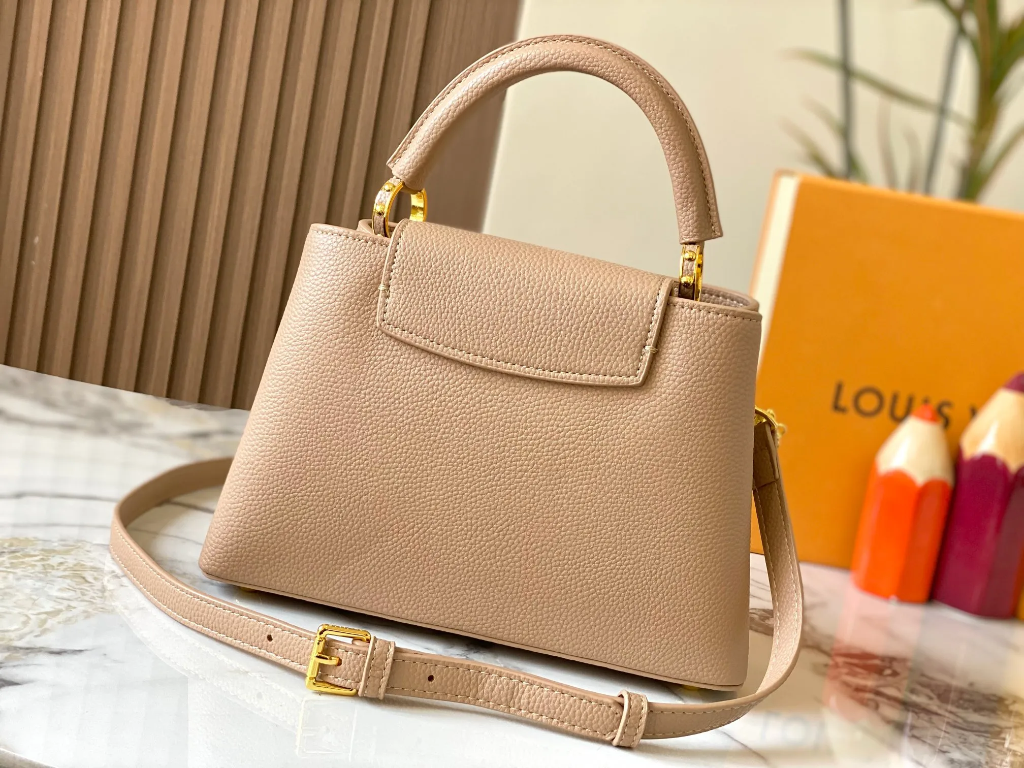 P500 [Guangzhou top quality original version] M26532 apricot color. This modern version of Capucines BB is made of timeless Taurillon leather and equipped with a jewelry-inspired Infinity chain. The bag is decorated with double galvanized metal parts, including the iconic Monogram floral pattern, and the LV Initials logo created with sunburst technology, creating a sundial-like light and shadow effect. The bag has multiple pockets and a detachable shoulder strap, allowing it to be carried on one shoulder or across the body. 27 x 17.3 x 9 (cm) (length x height x width)