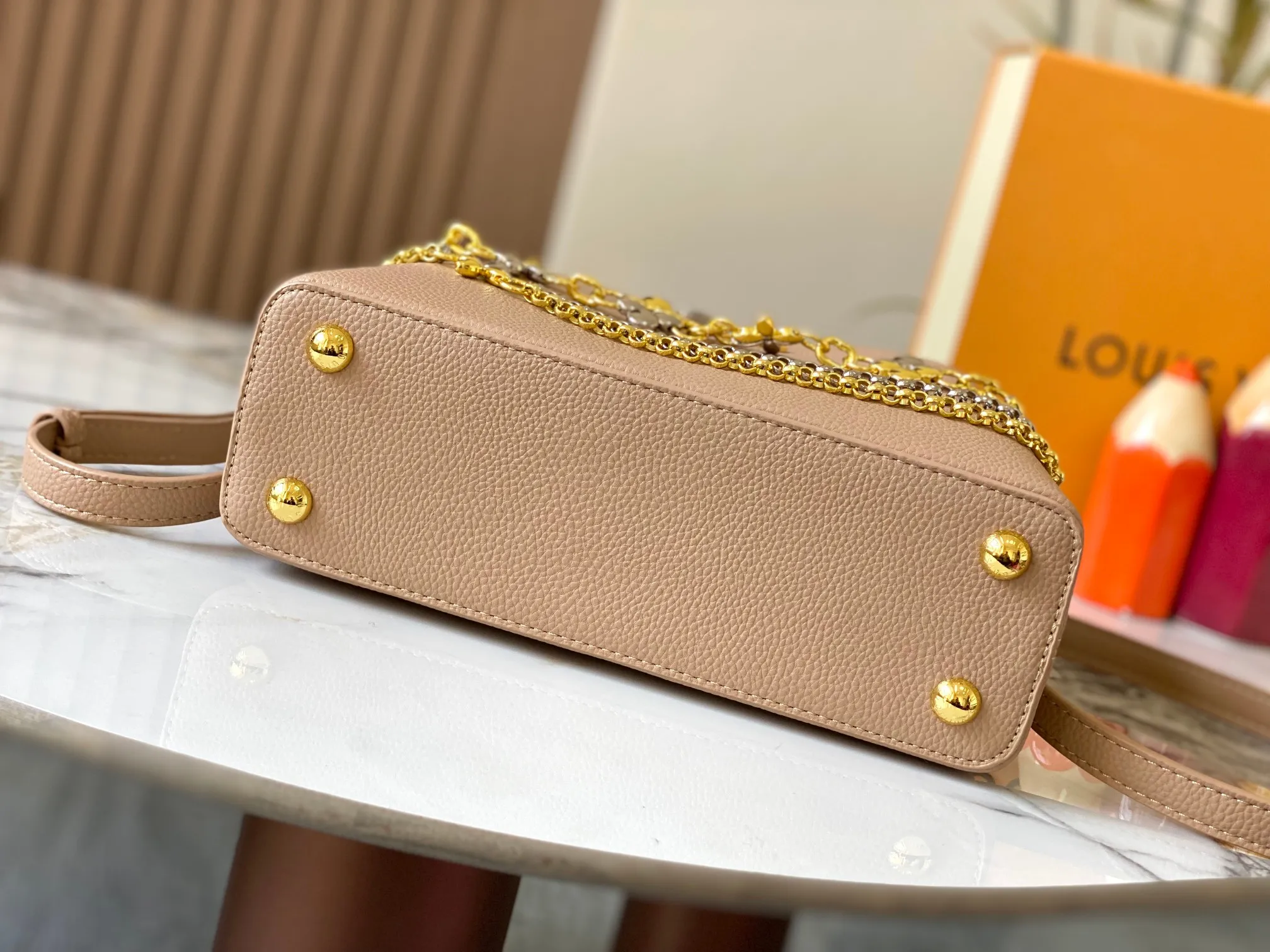 P500 [Guangzhou top quality original version] M26532 apricot color. This modern version of Capucines BB is made of timeless Taurillon leather and equipped with a jewelry-inspired Infinity chain. The bag is decorated with double galvanized metal parts, including the iconic Monogram floral pattern, and the LV Initials logo created with sunburst technology, creating a sundial-like light and shadow effect. The bag has multiple pockets and a detachable shoulder strap, allowing it to be carried on one shoulder or across the body. 27 x 17.3 x 9 (cm) (length x height x width)