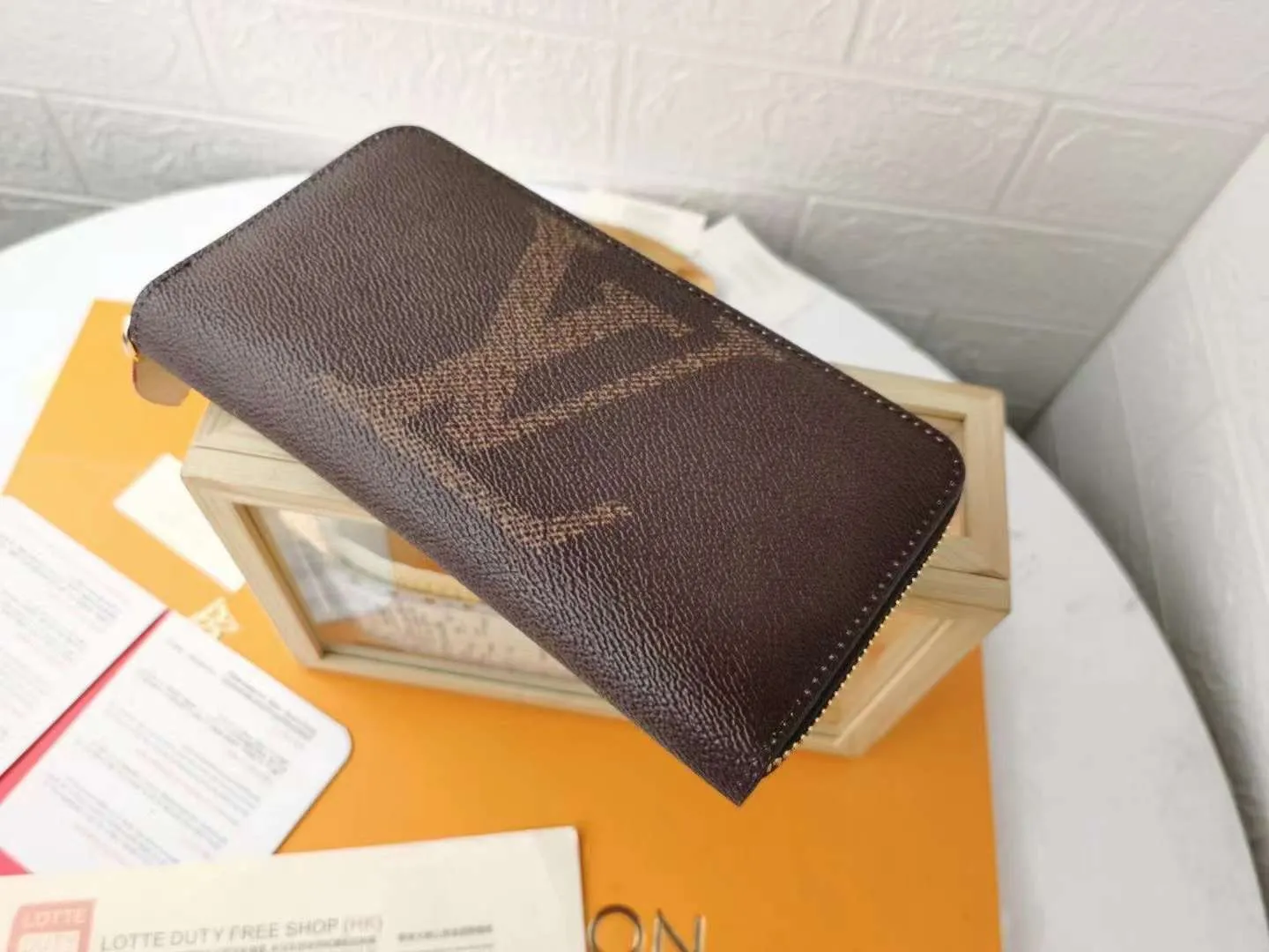 P140M60017 Light Brown Large Characters Dark Brown Large Characters ZIppy Zipper Wallet Printed canvas zipper coin purse, the large LV letters and Monogram floral pattern are particularly eye-catching. The compact zipper wallet is one of the classic designs. This wallet can hold banknotes, credit cards, small change, IDs, etc. Size 19x10cm.