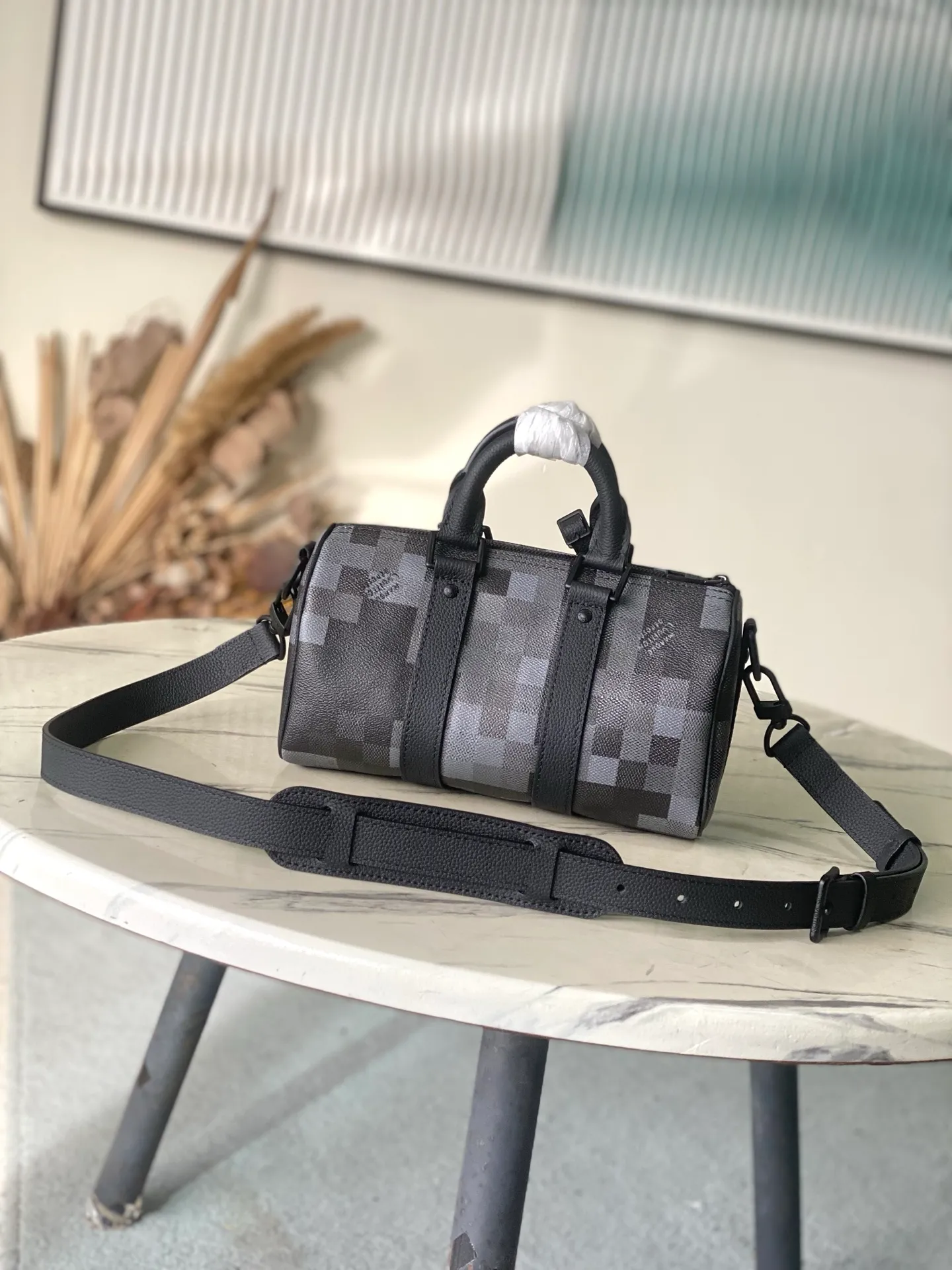 💰940 Top Original Order M14919 Large Keepal Bandouliere 25 Handbag is made of Damoflage Black coated canvas, which vividly reproduces the Damier Graphite pattern under Pharrell Wiliams’ creative aesthetics. The classic plaid presents a pixelated effect, and uses deep tones to create a unique camouflage appearance. The top handle and removable and adjustable shoulder strap provide multiple carrying options. Dimensions: 25 × 15 × 11 cm