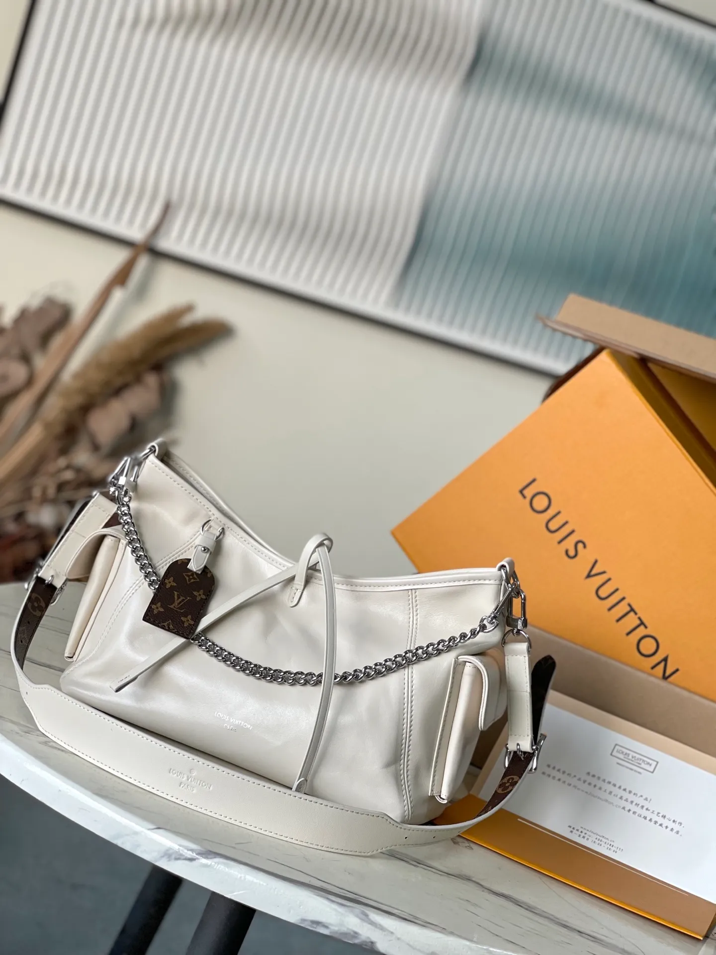💰1100 (top layer leather) top original order M12919 milk white. This small CarryAll Cargo handbag is made of soft sheep leather to create a fashionable and lazy silhouette, adding eye-catching charm to the 2024 spring and summer show style. Polished metal pieces are complemented by a tactile, slightly wrinkled texture. Plenty of space can accommodate a variety of daily necessities, making it a great travel companion. Dimensions: 33.5x 23x 15 cm