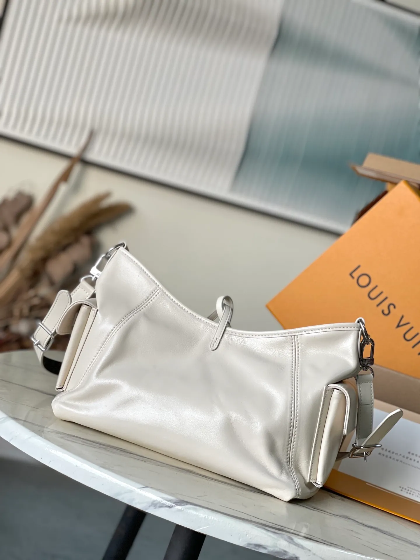 💰1100 (top layer leather) top original order M12919 milk white. This small CarryAll Cargo handbag is made of soft sheep leather to create a fashionable and lazy silhouette, adding eye-catching charm to the 2024 spring and summer show style. Polished metal pieces are complemented by a tactile, slightly wrinkled texture. Plenty of space can accommodate a variety of daily necessities, making it a great travel companion. Dimensions: 33.5x 23x 15 cm