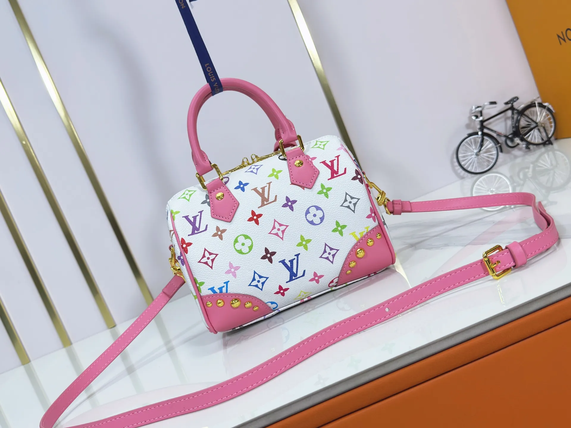 P280 upgraded original M58953 M46234 M46222 Speedy Bandoulière 20 handbag is made of soft coated canvas, and the full-length Monogram pattern is traced in colorful rainbow tones, highlighting the smart style of the Louis Vuitton x Murakami reissue series. The Toron handle and detachable shoulder strap are constructed of cow leather, the metal corners recall classic luggage elements, and the bow-shaped key bag and padlock add brand touches. Dimensions: 20.5 x 13.5 x 12.0 cm (length x height x width)