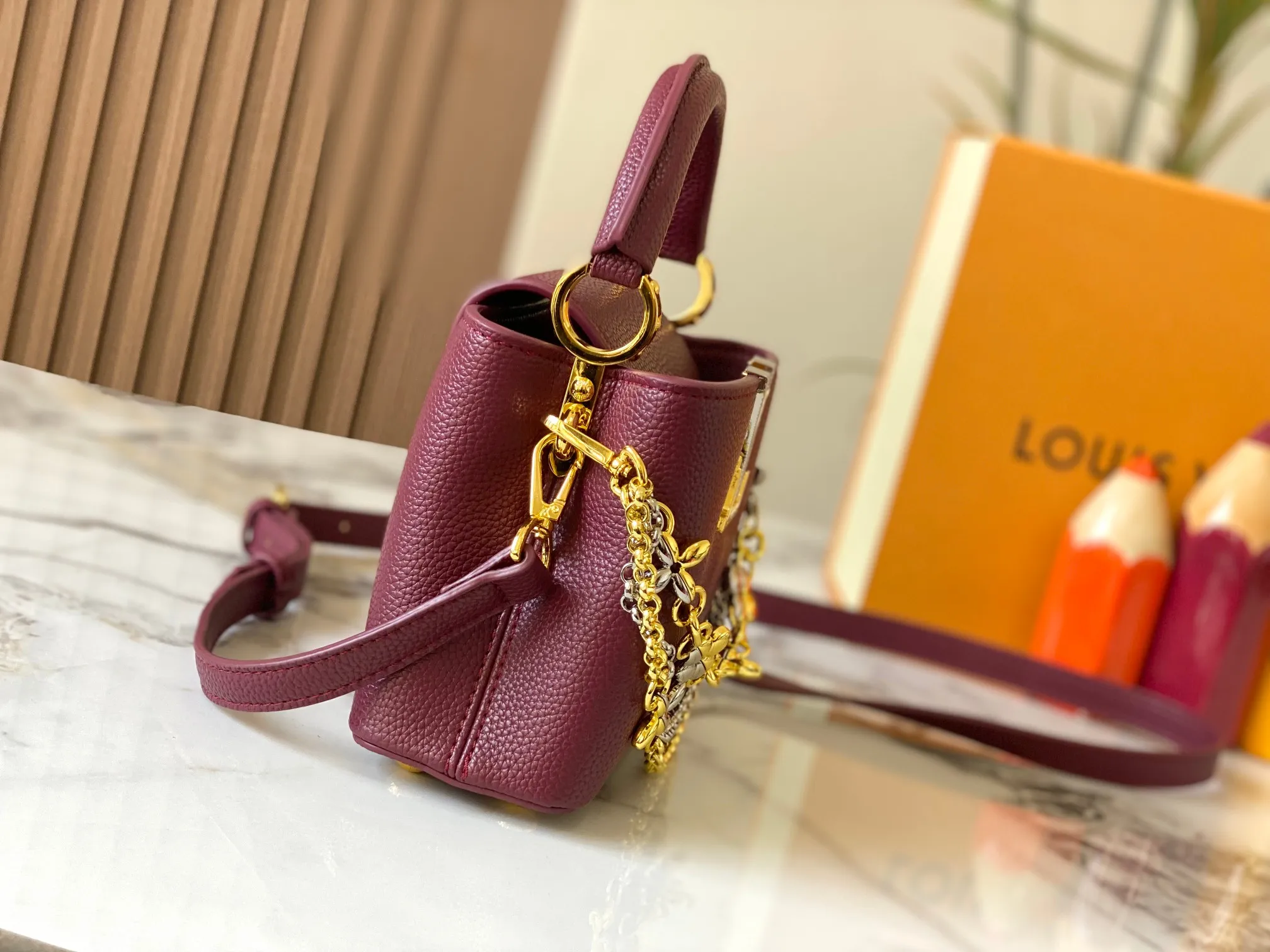 P480 [Guangzhou top quality original version] M26351 Bordeaux Red This modern version of Capucines mini is made of timeless Taurillon leather and equipped with a jewelry-inspired Infinity chain. The bag is decorated with double galvanized metal parts, including the iconic Monogram floral pattern, and the LV Initials logo created with sunburst technology, creating a sundial-like light and shadow effect. The bag has multiple pockets and a detachable shoulder strap, allowing it to be carried on one shoulder or across the body. 14 x 8 x 21 cm (height x width x length)