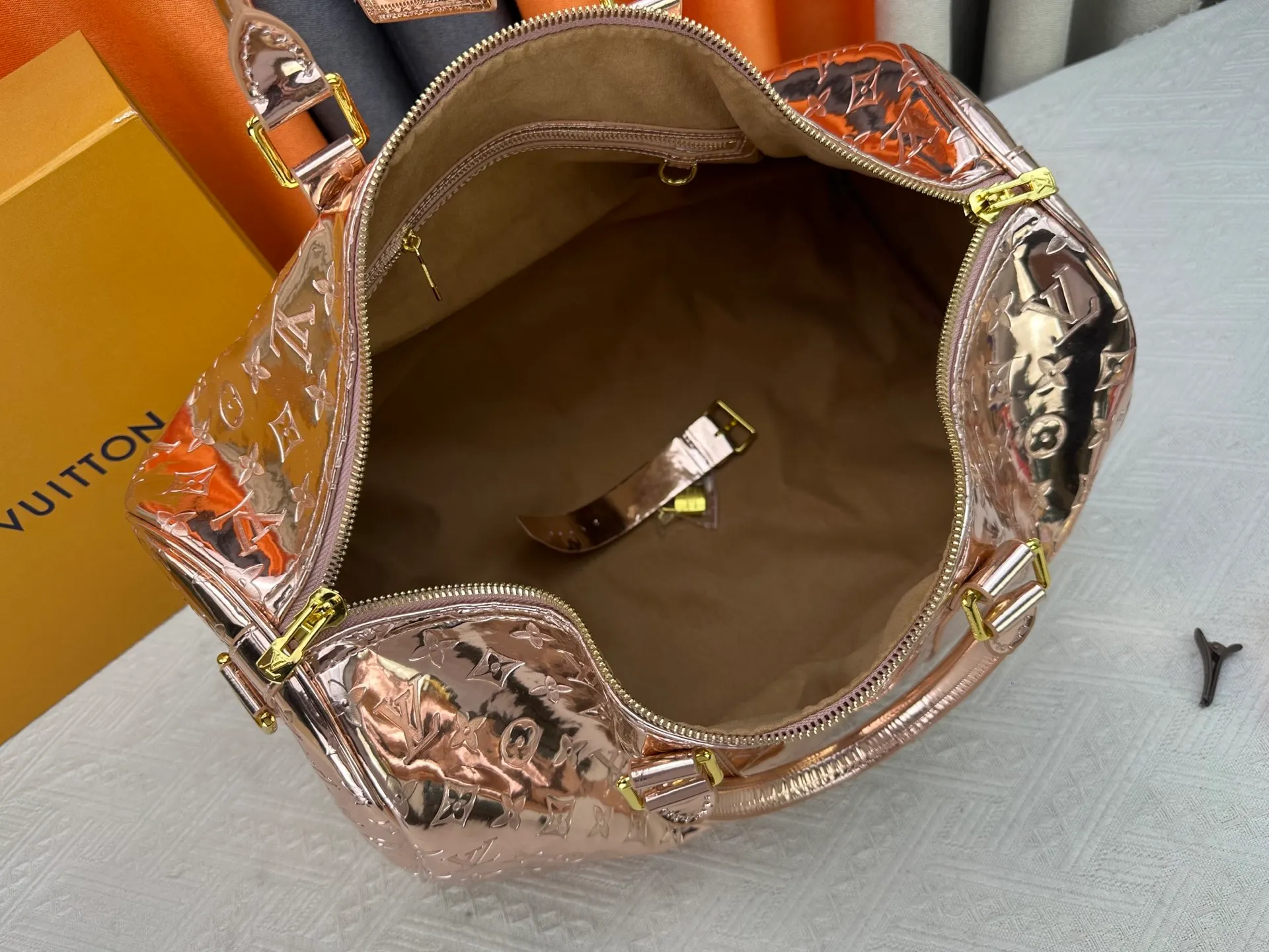 P360 M26463 M41418 Rose Gold This Speedy Bandoulière 45 handbag is from the LV Ski series. It is made of embossed coated canvas decorated with smooth leather trim and bright metal parts, and then uses the new Monogram Miroir effect to declare the retro-futuristic concept. The detachable and adjustable leather shoulder strap allows for a variety of carrying options, and the compact design can accommodate daily needs such as a long wallet. Dimensions: 45x27x20