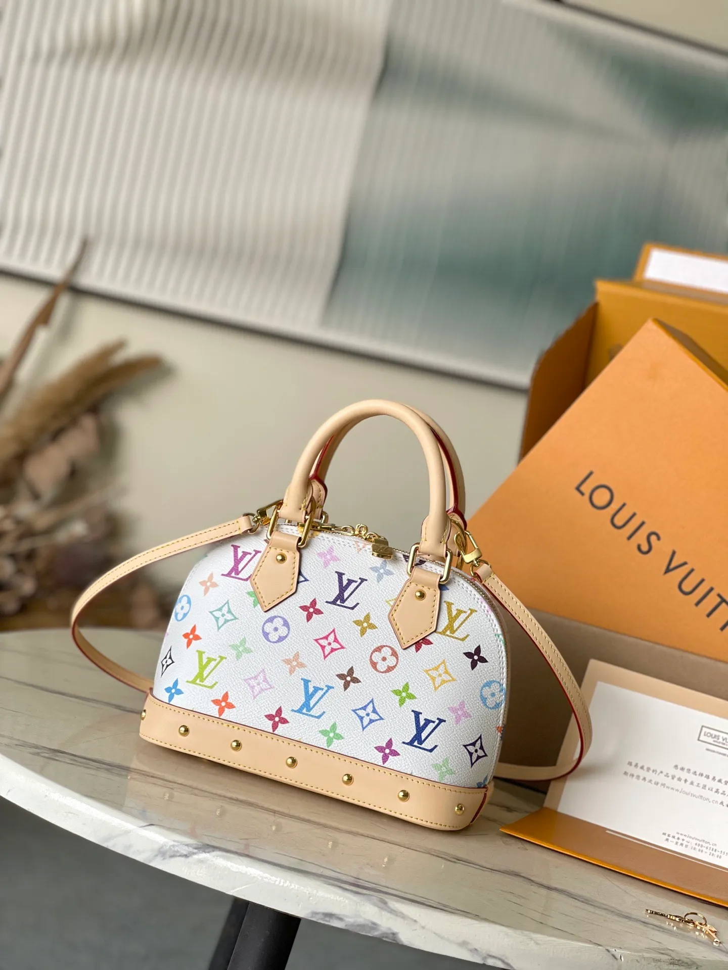 💰1080 Top original order M13078 This AmaBB handbag is filled with the joyful style of the Louis Vuitton x Murakami collaboration series, cleverly recalling the Art Deco style design of the 1930s. Monogram coated canvas is dyed in Murakami’s playful tones, and classic cow leather elements are incorporated into the Toron handle, bag base, detachable shoulder strap and LVxTM key bag. Dimensions: 23.5 × 17.5 × 11.5 cm
