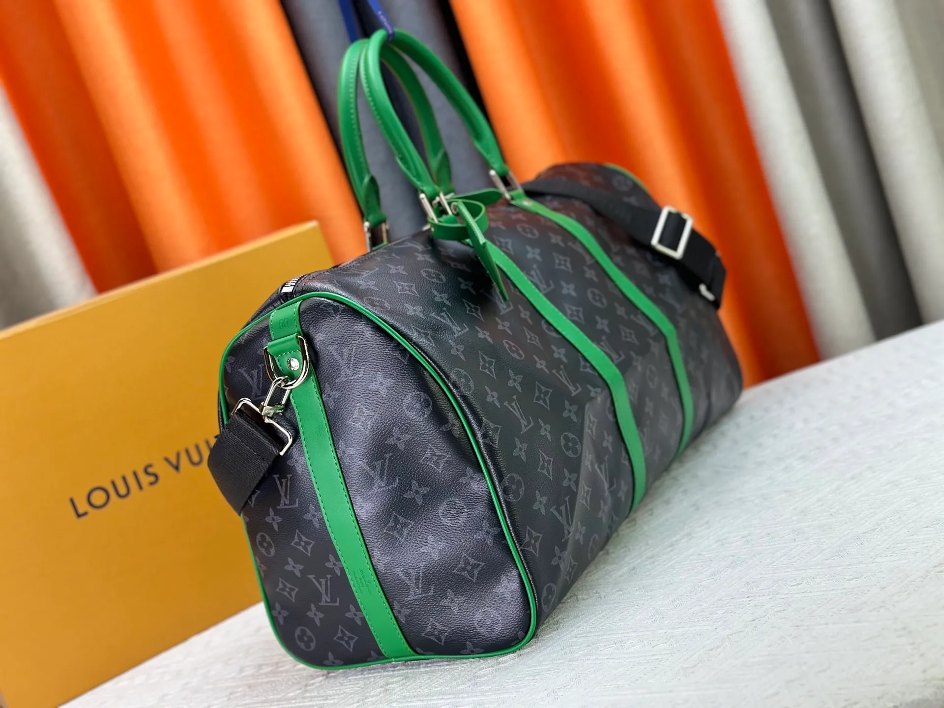 P340 M26434 M41416 Upgraded from the original version, this Keepall Bandoulière 50 travel bag is made of Monogram Eclipse canvas, with bright side straps and top handles to inject a dynamic feel. Compact construction with fabric lining and zippered pockets for on-the-go convenience. The removable and adjustable shoulder strap allows for shoulder or cross-body wear. 29 x 23 x 50 cm (height x width x length)