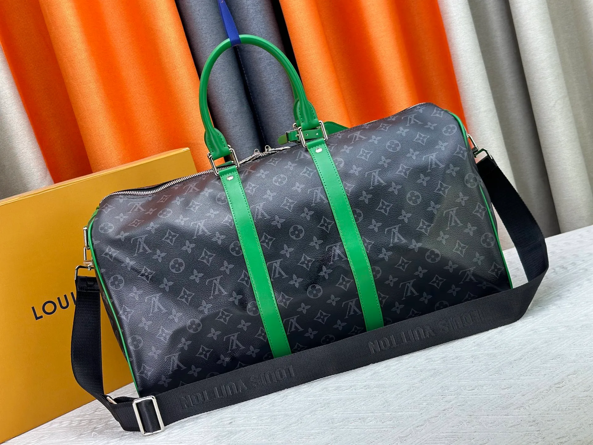 P340 M26434 M41416 Upgraded from the original version, this Keepall Bandoulière 50 travel bag is made of Monogram Eclipse canvas, with bright side straps and top handles to inject a dynamic feel. Compact construction with fabric lining and zippered pockets for on-the-go convenience. The removable and adjustable shoulder strap allows for shoulder or cross-body wear. 29 x 23 x 50 cm (height x width x length)