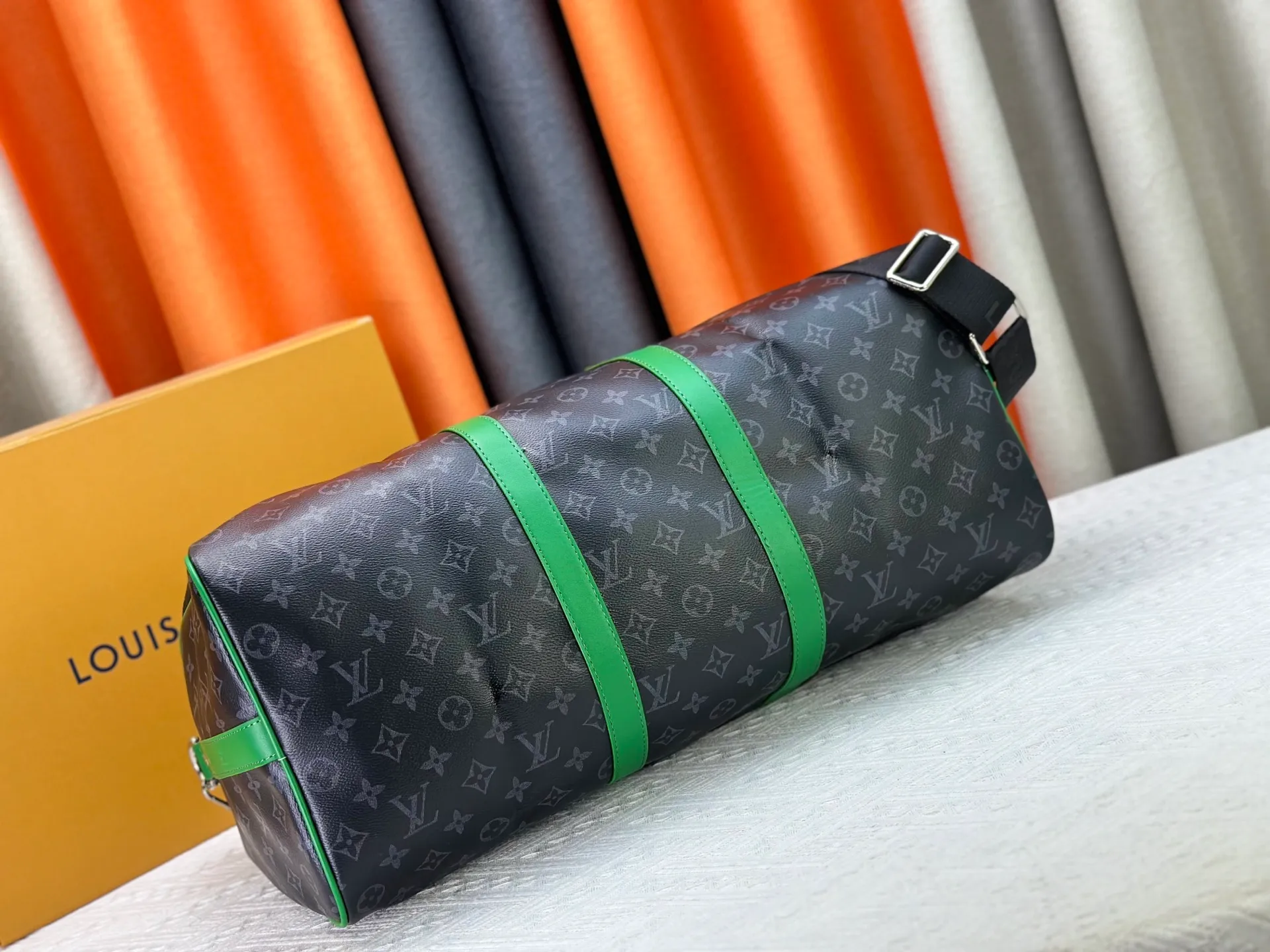 P340 M26434 M41416 Upgraded from the original version, this Keepall Bandoulière 50 travel bag is made of Monogram Eclipse canvas, with bright side straps and top handles to inject a dynamic feel. Compact construction with fabric lining and zippered pockets for on-the-go convenience. The removable and adjustable shoulder strap allows for shoulder or cross-body wear. 29 x 23 x 50 cm (height x width x length)