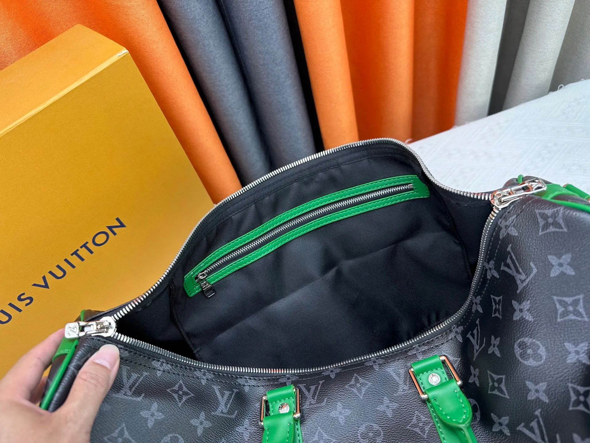 P340 M26434 M41416 Upgraded from the original version, this Keepall Bandoulière 50 travel bag is made of Monogram Eclipse canvas, with bright side straps and top handles to inject a dynamic feel. Compact construction with fabric lining and zippered pockets for on-the-go convenience. The removable and adjustable shoulder strap allows for shoulder or cross-body wear. 29 x 23 x 50 cm (height x width x length)