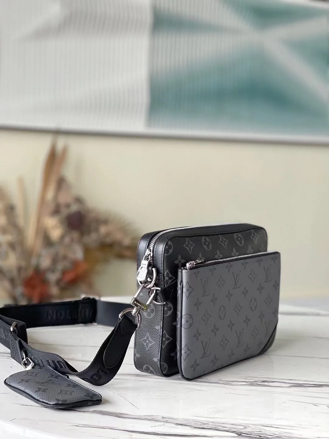 💰720 Top original M69443 Trio messenger bag is made of Monogram Eclipse canvas and Monogram Eclipse Reverse canvas. A signature tonal gray pattern accentuates the lines of this versatile, modular design. In addition to the functions of a traditional cross-body bag, it also comes with a removable zipper bag and a coin purse attached to the strap. Dimensions: 25 x 18.5 x 7 cm