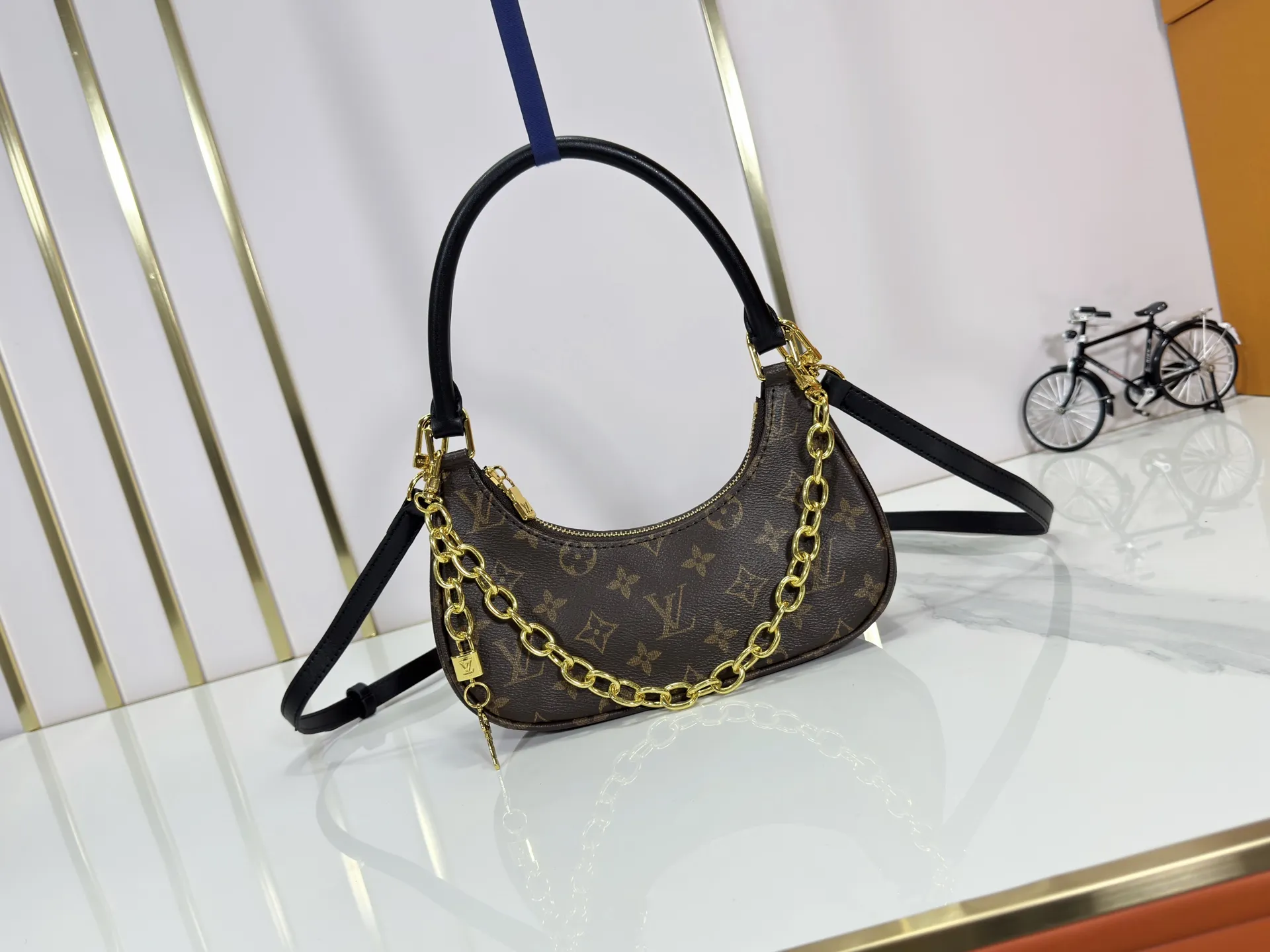 P240 Upgraded original M25223 This small Catchy handbag is made of canvas and trimmed with cow leather. It pays homage to the brand's heritage with the classic Monogram pattern, making it another smart choice. The neat structure makes it easy to carry your daily needs. The double-sided sliding straps make it easy to adjust the contours of the bag. The detachable metal chain complements the key-shaped decoration. Dimensions: 24.0 x 10.0 x 6.0 cm (length x height x width)