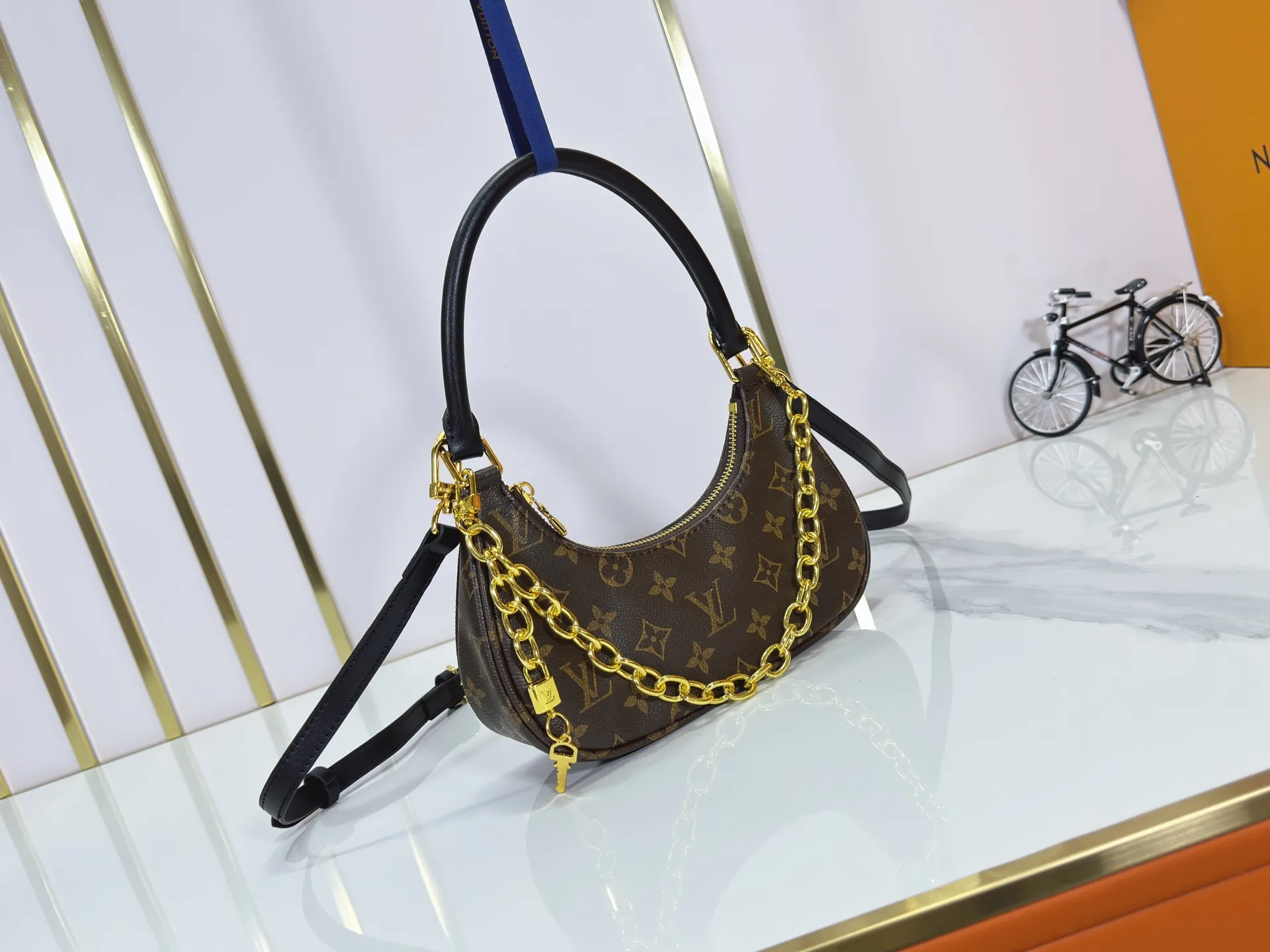 P240 Upgraded original M25223 This small Catchy handbag is made of canvas and trimmed with cow leather. It pays homage to the brand's heritage with the classic Monogram pattern, making it another smart choice. The neat structure makes it easy to carry your daily needs. The double-sided sliding straps make it easy to adjust the contours of the bag. The detachable metal chain complements the key-shaped decoration. Dimensions: 24.0 x 10.0 x 6.0 cm (length x height x width)