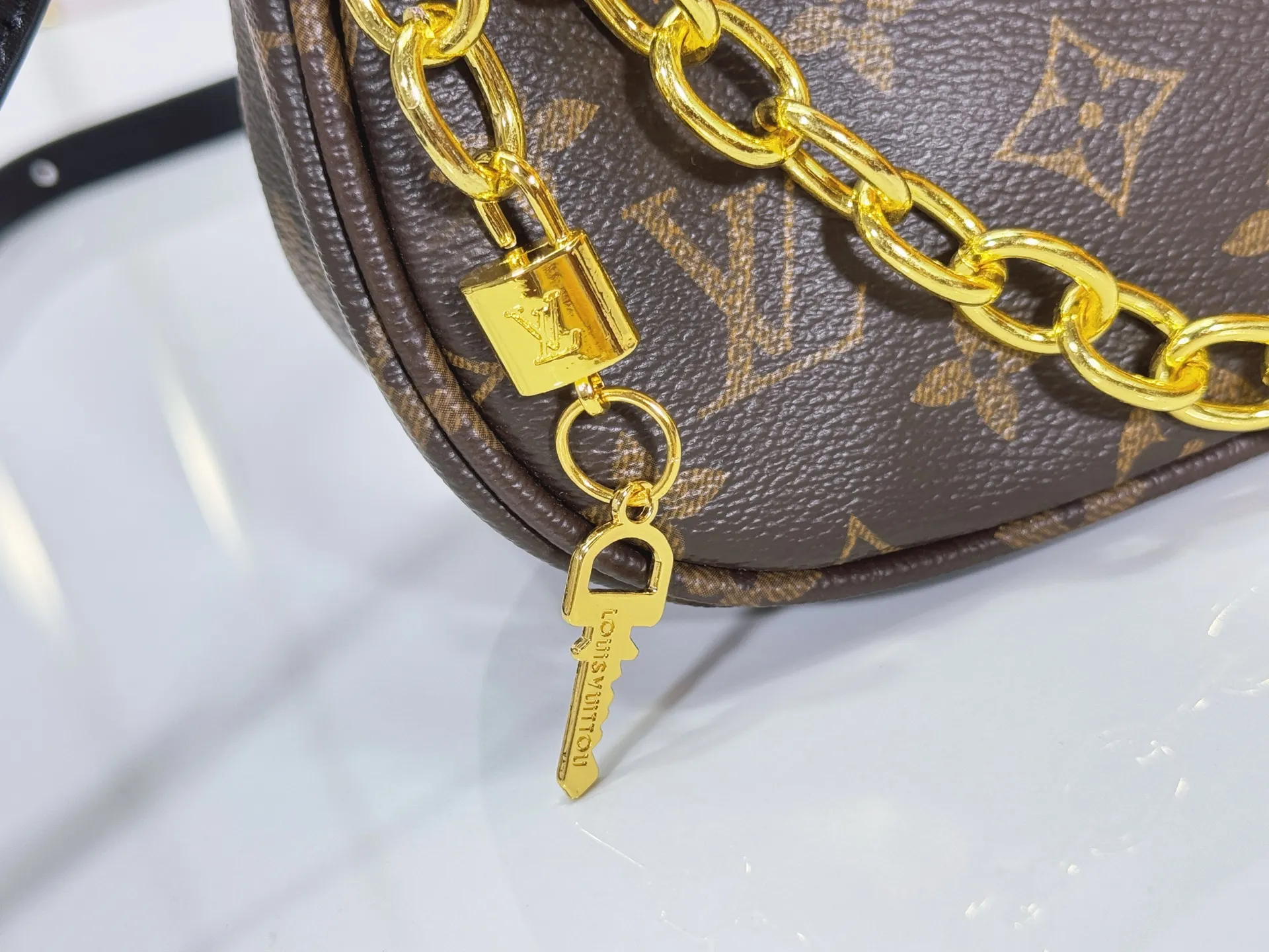 P240 Upgraded original M25223 This small Catchy handbag is made of canvas and trimmed with cow leather. It pays homage to the brand's heritage with the classic Monogram pattern, making it another smart choice. The neat structure makes it easy to carry your daily needs. The double-sided sliding straps make it easy to adjust the contours of the bag. The detachable metal chain complements the key-shaped decoration. Dimensions: 24.0 x 10.0 x 6.0 cm (length x height x width)