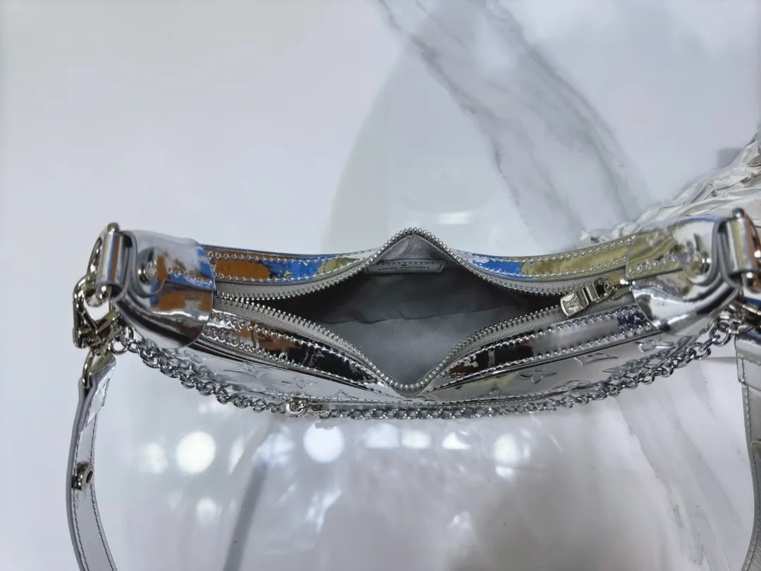 P280 Upgraded original [loop handbag] M11833 silver patent leather. This small loop handbag is from the v ski series. It draws inspiration from the brand’s classic metal hard case from 1892, and renders the monogram miroir effect on the monogram embossed coated canvas, giving the traditional aesthetics a retro-futuristic feel. The adjustable leather shoulder strap and chain are detachable, making it a flexible choice for storing essentials and a long wallet when traveling day or night. Dimensions: 13x6x23 cm.