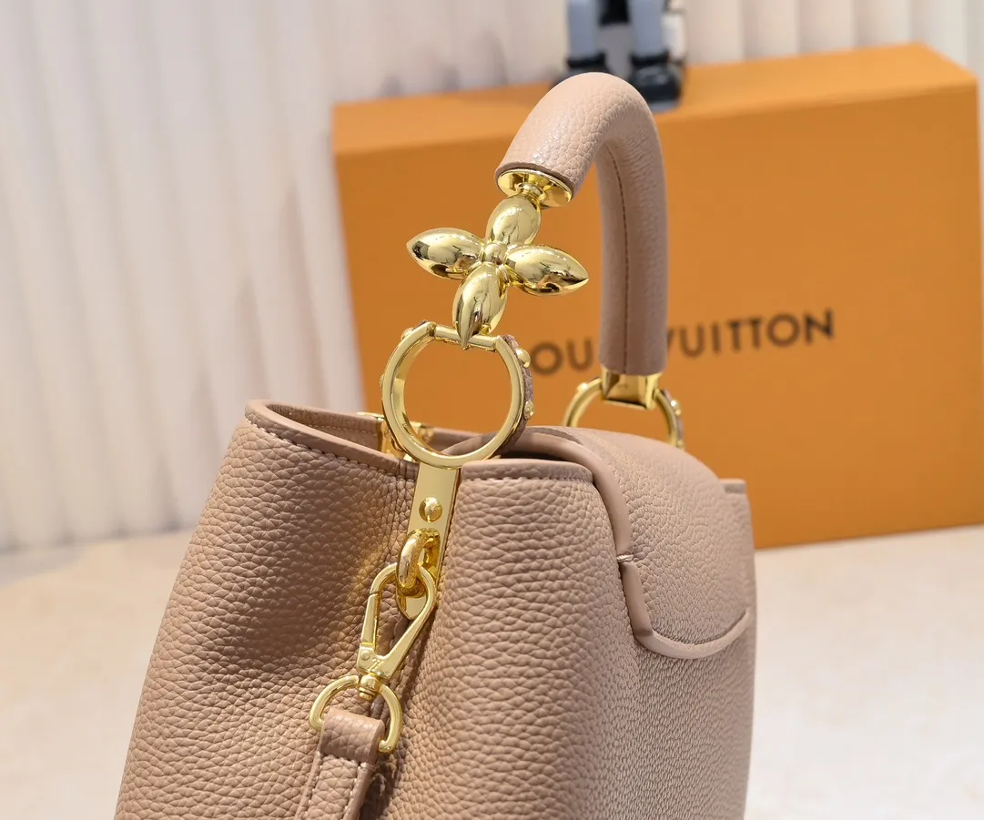 The upgraded version of the P460 M24698 Capucines BB handbag is made of Taurillon cow leather decorated with shiny metal parts, and the LV letters are written in 3D strokes. Metal Monogram flowers bloom quietly on the rolled leather handle, subtly proving the brand's exquisite craftsmanship. The detachable and adjustable leather shoulder strap allows for comfortable shoulder carrying. Detailed features 26.5 x17.5 x9 cm