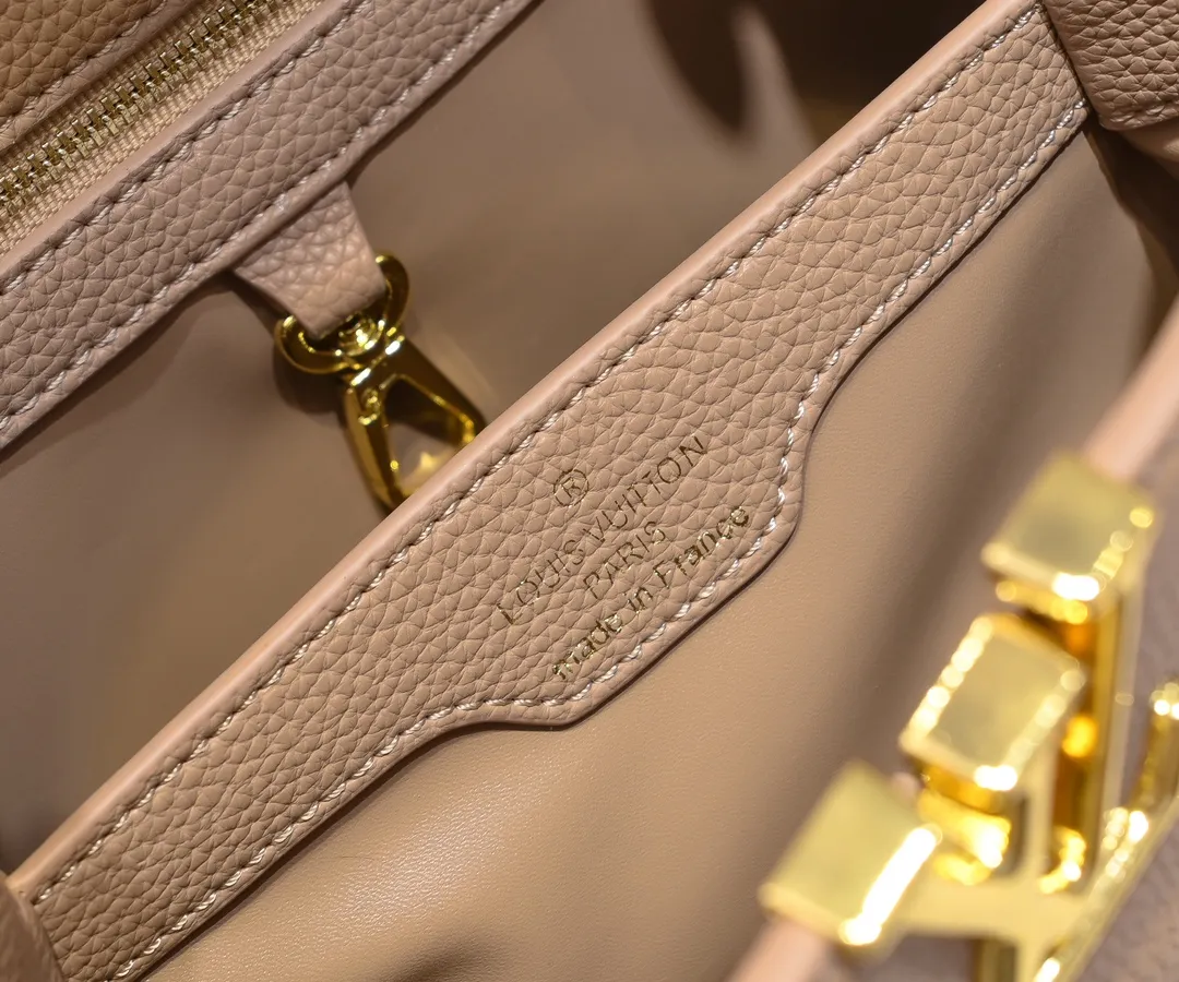 The upgraded version of the P460 M24698 Capucines BB handbag is made of Taurillon cow leather decorated with shiny metal parts, and the LV letters are written in 3D strokes. Metal Monogram flowers bloom quietly on the rolled leather handle, subtly proving the brand's exquisite craftsmanship. The detachable and adjustable leather shoulder strap allows for comfortable shoulder carrying. Detailed features 26.5 x17.5 x9 cm