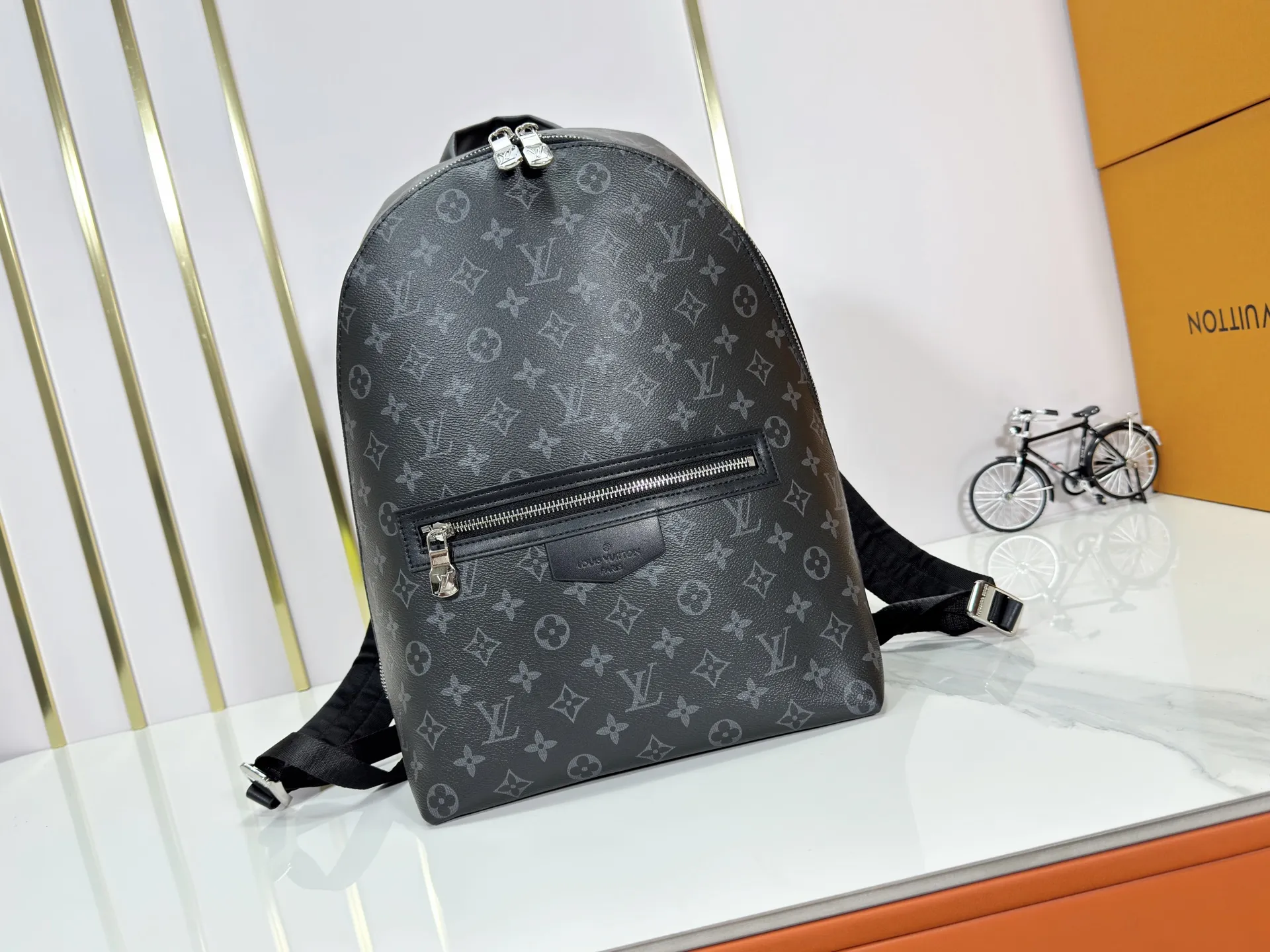 P300 upgraded original M14020 black flower. Lime green. Presbyopia. Black check This Discovery Slim double shoulder bag is made of Monogram Eclipse coated canvas. It has a compact structure and can be integrated into the laptop pocket. It can easily be used in business, leisure or leisure occasions with a trendy attitude. The adjustable shoulder straps with fabric lining enhance the comfortable carrying experience, and the zippered front pocket makes it easy to store daily necessities. Size:38x13x28cm