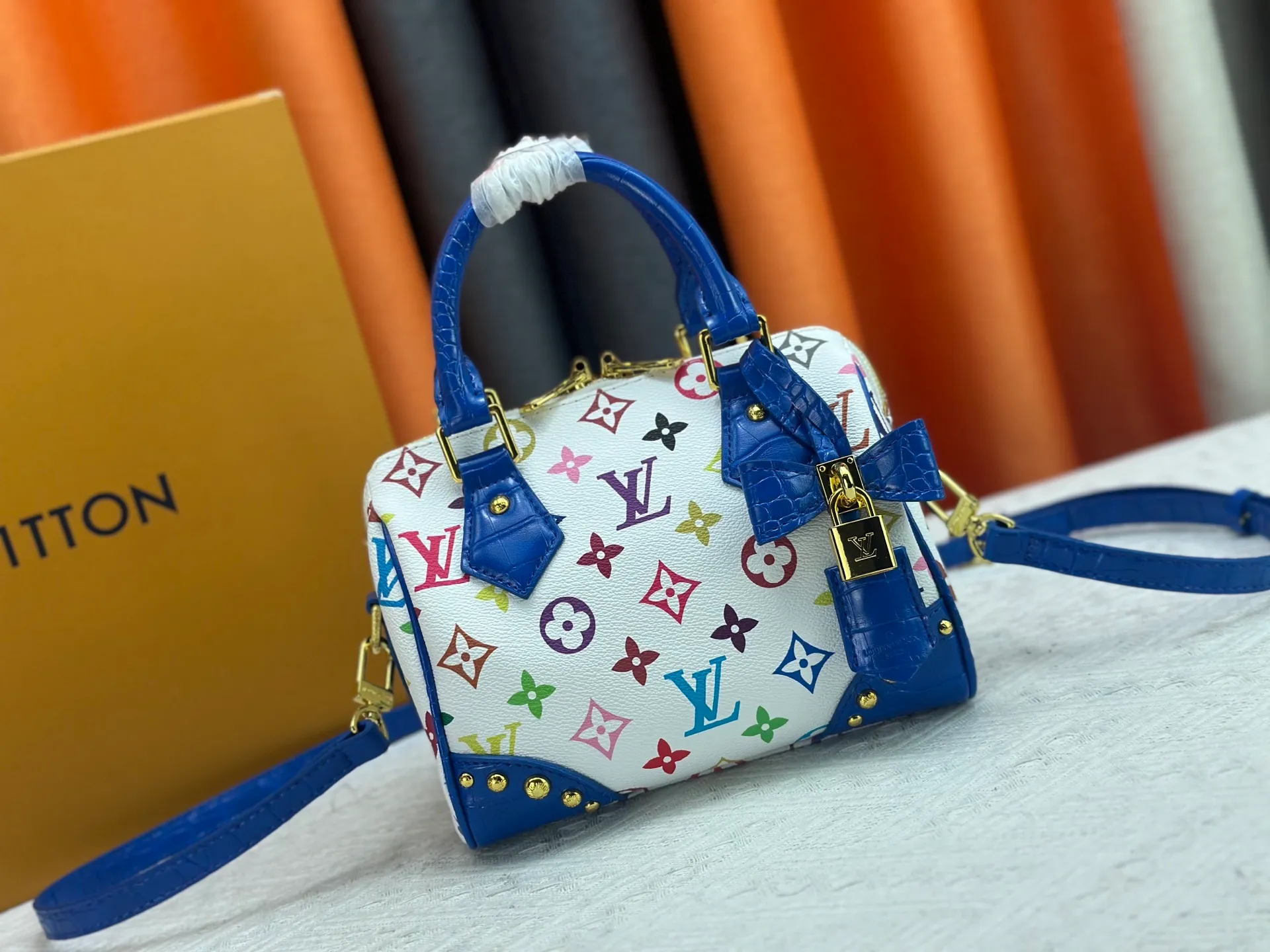 P260 Upgraded original crocodile pattern M13365 M58953 M46234 M46222 Speedy Bandoulière 20 handbag is made of soft coated canvas, and the full-length Monogram pattern is traced in colorful rainbow tones, highlighting the smart style of the Louis Vuitton x Murakami reissue series. The Toron handle and detachable shoulder strap are constructed of cow leather, the metal corners recall classic luggage elements, and the bow-shaped key bag and padlock add brand touches. Dimensions: 20.5 x 13.5 x 12.0 cm (length x height x width)