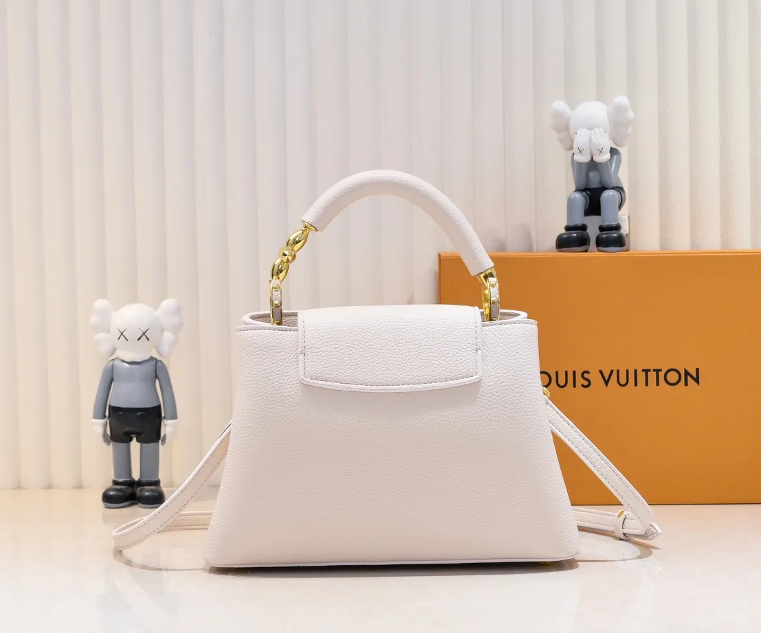 The upgraded version of the P460 M24698 Capucines BB handbag is made of Taurillon cow leather decorated with shiny metal parts, and the LV letters are written in 3D strokes. Metal Monogram flowers bloom quietly on the rolled leather handle, subtly proving the brand's exquisite craftsmanship. The detachable and adjustable leather shoulder strap allows for comfortable shoulder carrying. Detailed features 26.5 x17.5 x9 cm