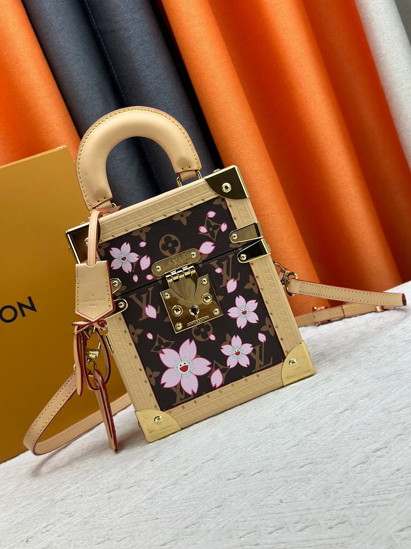 P620 upgraded version [Camera Box Hard Case Handbag] Presbyopia/Sakura (Takashi Murakami) replica M14173 M10079 This Camera Box handbag happily joins the Louis Vuitton x Murakami series, incorporating new details into the Monogram coated canvas, and paying tribute to the brand's classic hard case with a slender silhouette. The Cherry Blossom pattern reflects the bright brushstrokes of the Japanese artist, and cowhide leather trim and dazzling hardware complete the look. 21.5 x 10.5 x 17.5 cm (height x width x length)