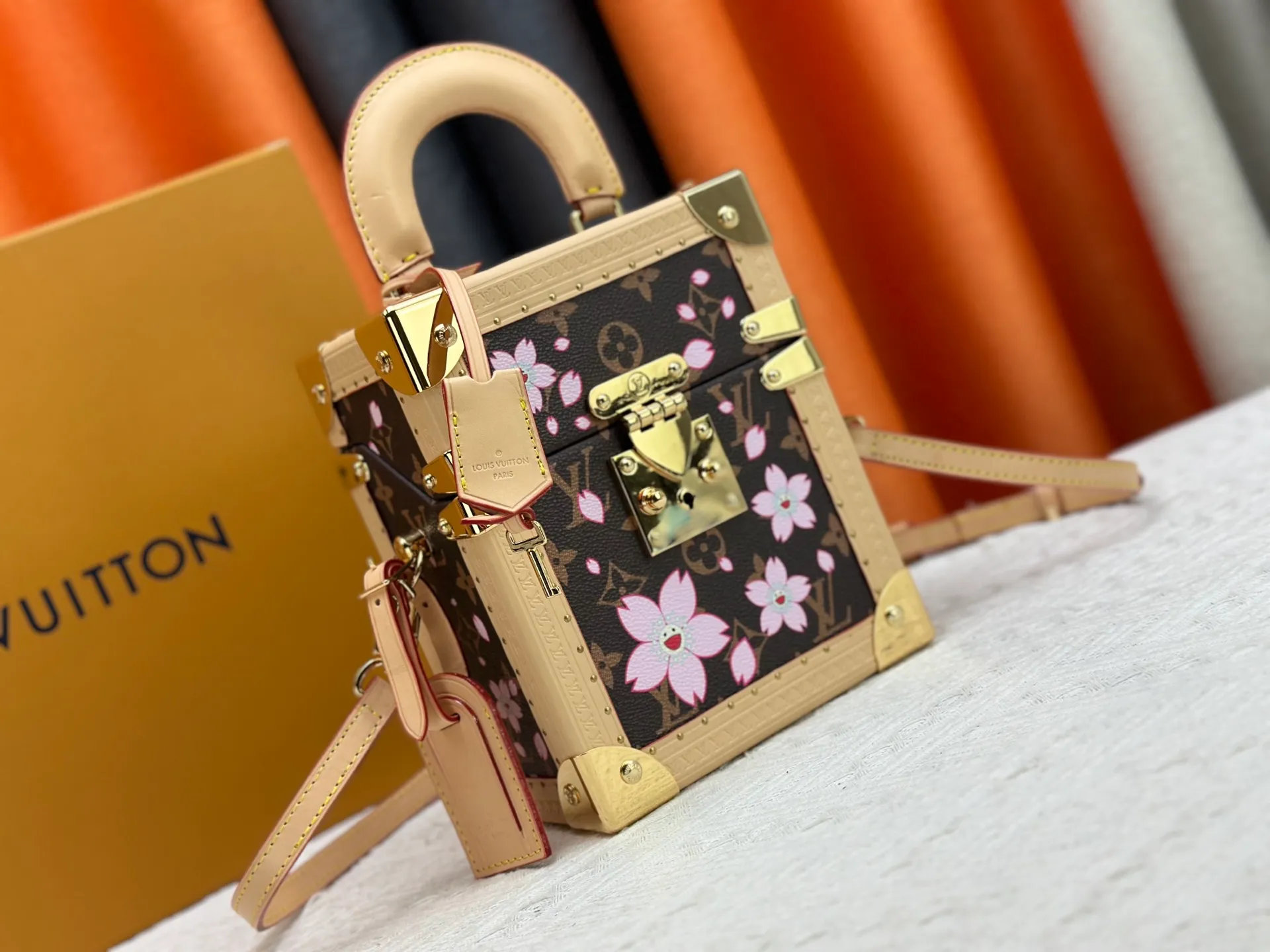 P620 upgraded version [Camera Box Hard Case Handbag] Presbyopia/Sakura (Takashi Murakami) replica M14173 M10079 This Camera Box handbag happily joins the Louis Vuitton x Murakami series, incorporating new details into the Monogram coated canvas, and paying tribute to the brand's classic hard case with a slender silhouette. The Cherry Blossom pattern reflects the bright brushstrokes of the Japanese artist, and cowhide leather trim and dazzling hardware complete the look. 21.5 x 10.5 x 17.5 cm (height x width x length)