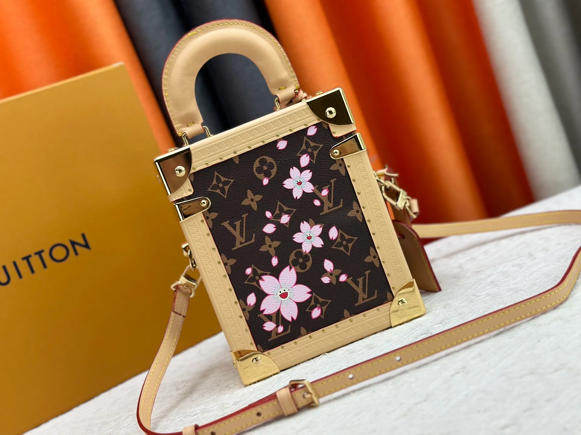 P620 upgraded version [Camera Box Hard Case Handbag] Presbyopia/Sakura (Takashi Murakami) replica M14173 M10079 This Camera Box handbag happily joins the Louis Vuitton x Murakami series, incorporating new details into the Monogram coated canvas, and paying tribute to the brand's classic hard case with a slender silhouette. The Cherry Blossom pattern reflects the bright brushstrokes of the Japanese artist, and cowhide leather trim and dazzling hardware complete the look. 21.5 x 10.5 x 17.5 cm (height x width x length)
