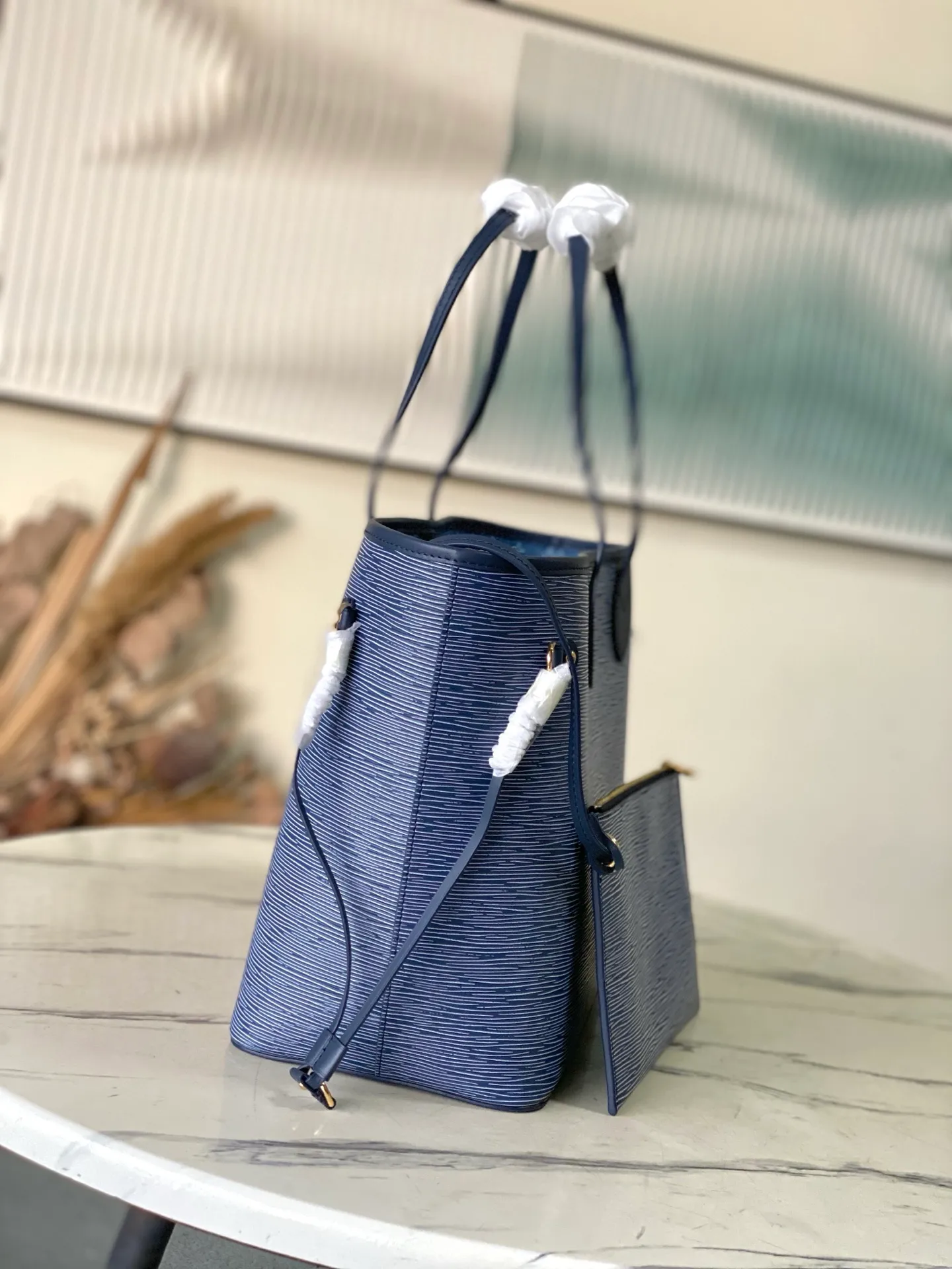 💰1340 (top layer leather) top original order M14856 (11930 blue and white) This Neverfull MM bag enhances the denim blue finish, which is both modern and timeless. This model is made of signature Spike leather with gold-tone metallic finish and has an interior lined with Monogram denim and a removable zipped Monogram pouch. Laces on the sides tighten the silhouette of the piece, which can be worn over the shoulder or by hand. Dimensions: 31x28x14 cm