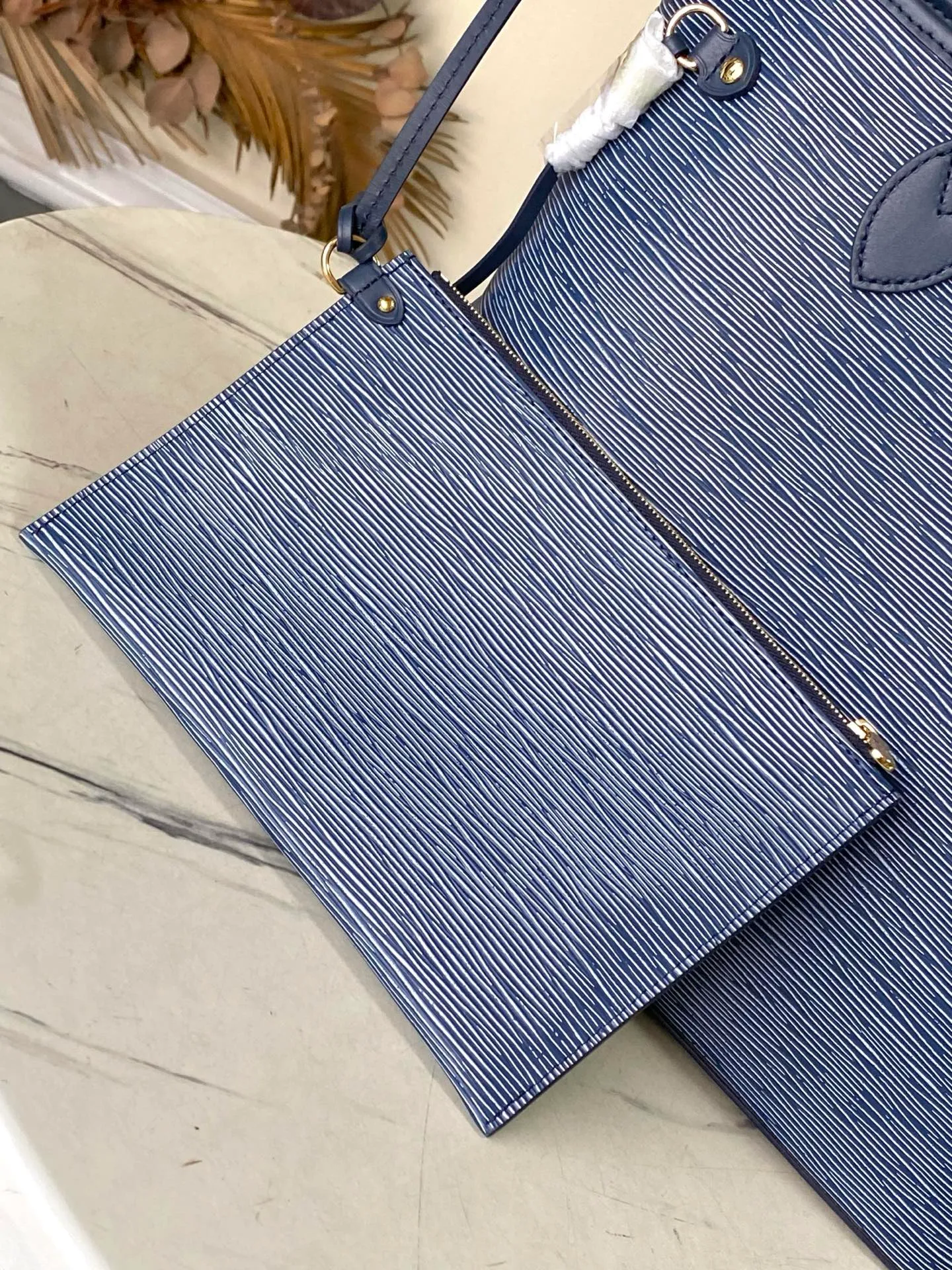 💰1340 (top layer leather) top original order M14856 (11930 blue and white) This Neverfull MM bag enhances the denim blue finish, which is both modern and timeless. This model is made of signature Spike leather with gold-tone metallic finish and has an interior lined with Monogram denim and a removable zipped Monogram pouch. Laces on the sides tighten the silhouette of the piece, which can be worn over the shoulder or by hand. Dimensions: 31x28x14 cm