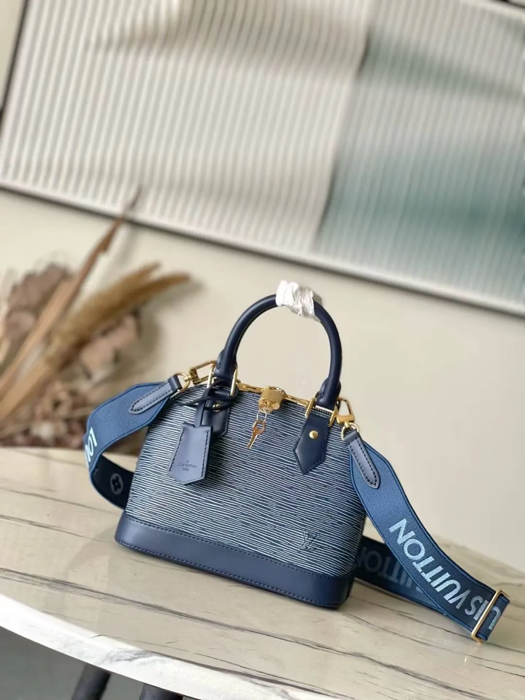 💰1500 Top original order M14853 (40302 blue and white fabric) This Alma BB bag is revisited in the latest denim blue Epi leather version. The textured effect is accompanied by a gold metallic finish, including a feature padlock and a keybell. The interior is enhanced with signature Monogram denim lining and is roomy enough to accommodate all the essentials for daily life. This model has a fabric shoulder strap to keep your hands free. 23.5 x 17.5 x 11.5 cm (LxHxW)