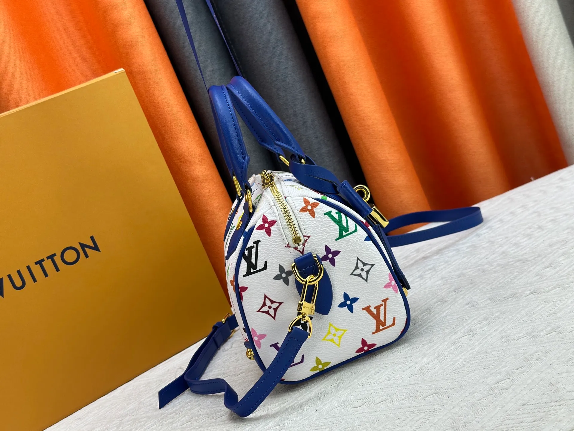 P260 upgraded original M58953 M46234 M46222 Speedy Bandoulière 20 handbag is made of soft coated canvas, and the full-length Monogram pattern is traced in colorful rainbow tones, highlighting the smart style of the Louis Vuitton x Murakami reissue series. The Toron handle and detachable shoulder strap are constructed of cow leather, the metal corners recall classic luggage elements, and the bow-shaped key bag and padlock add brand touches. Dimensions: 20.5 x 13.5 x 12.0 cm (length x height x width)
