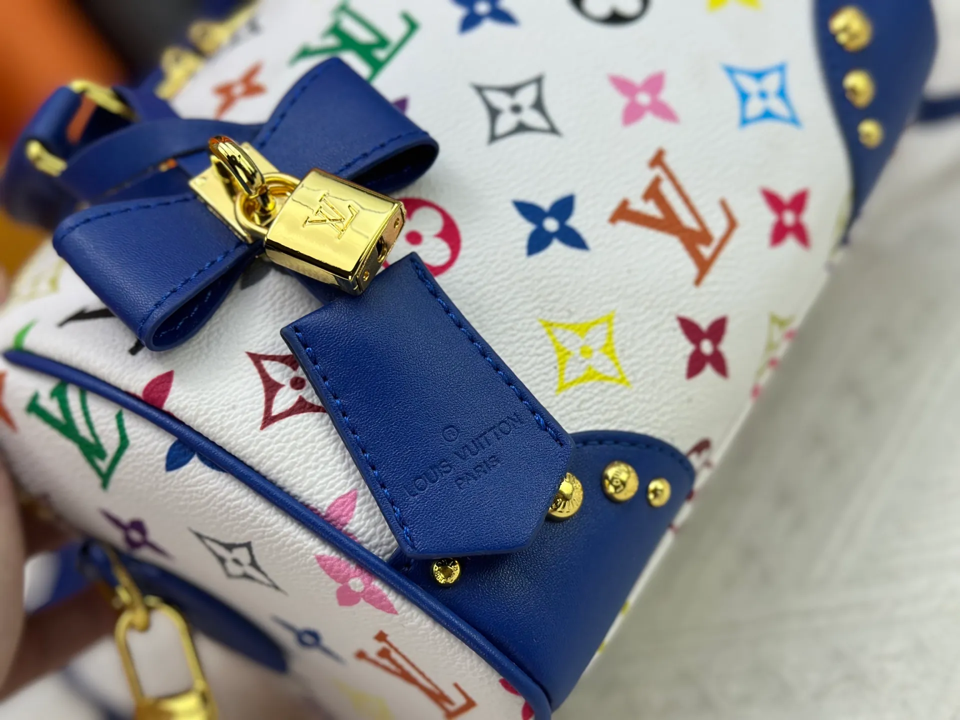 P260 upgraded original M58953 M46234 M46222 Speedy Bandoulière 20 handbag is made of soft coated canvas, and the full-length Monogram pattern is traced in colorful rainbow tones, highlighting the smart style of the Louis Vuitton x Murakami reissue series. The Toron handle and detachable shoulder strap are constructed of cow leather, the metal corners recall classic luggage elements, and the bow-shaped key bag and padlock add brand touches. Dimensions: 20.5 x 13.5 x 12.0 cm (length x height x width)