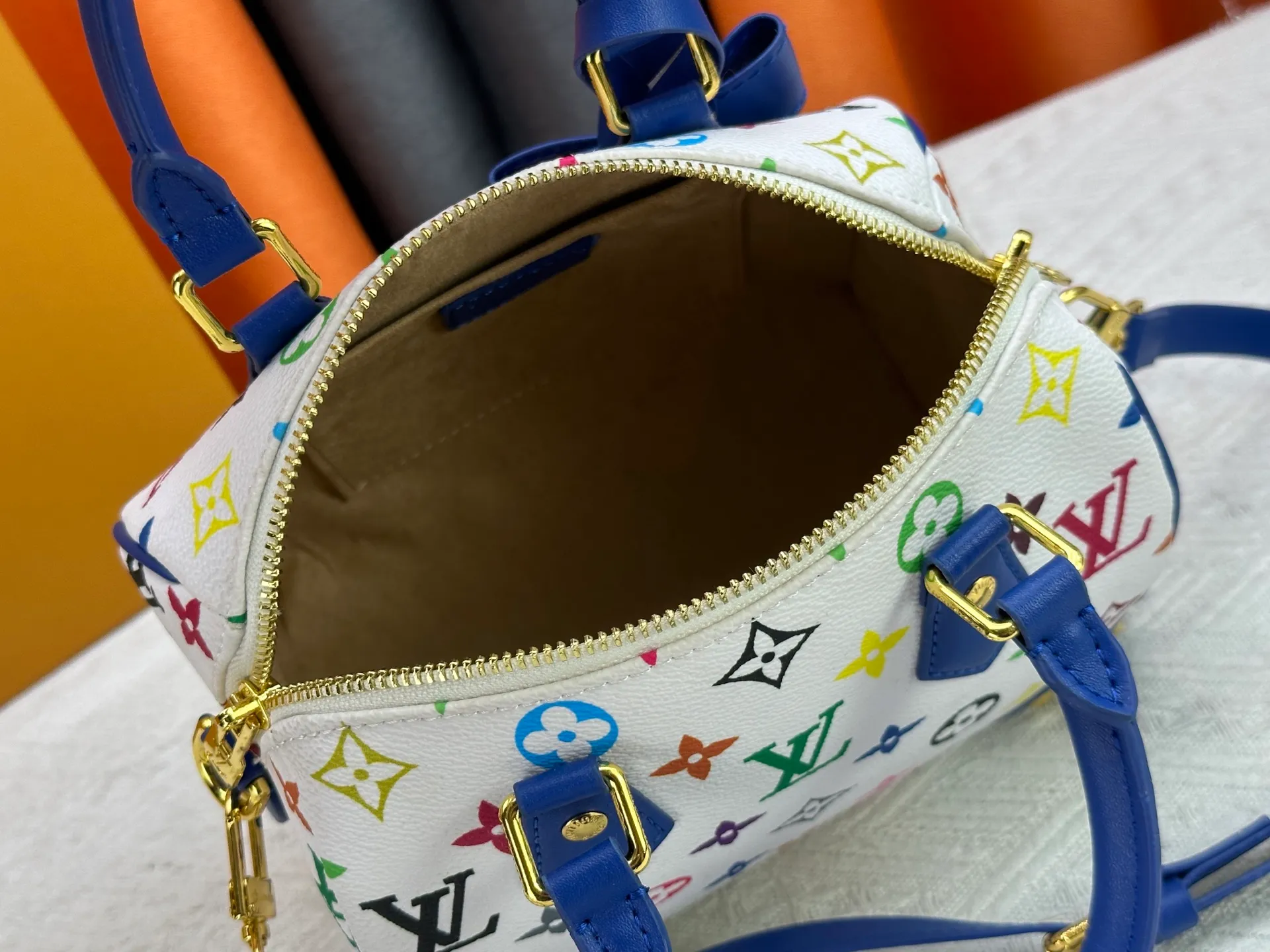 P260 upgraded original M58953 M46234 M46222 Speedy Bandoulière 20 handbag is made of soft coated canvas, and the full-length Monogram pattern is traced in colorful rainbow tones, highlighting the smart style of the Louis Vuitton x Murakami reissue series. The Toron handle and detachable shoulder strap are constructed of cow leather, the metal corners recall classic luggage elements, and the bow-shaped key bag and padlock add brand touches. Dimensions: 20.5 x 13.5 x 12.0 cm (length x height x width)