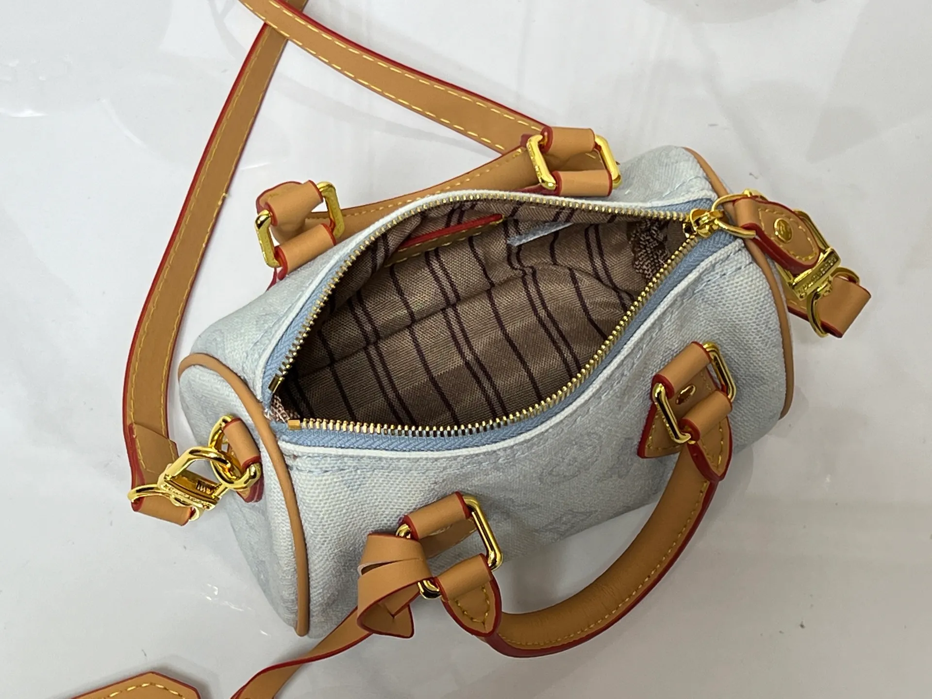Batch 240💰M28322 Red M28323 M27610 M81085 [Exclusive background shot] This Nano Speedy handbag condenses the configuration of Louis Vuitton's classic Speedy handbag. It is made of Monogram canvas with distressed cow leather details and dazzling metal parts, making it easy to carry with you for daily needs. The handles and removable and adjustable shoulder strap allow for a variety of styling possibilities. 16.0 x 10.0 x 7.5 cm (L x H x W) • Monogram coated canvas • Cow leather trim • Metal hardware • Zipper closure • Space to store daily necessities such as a 6.1-inch smartphone, card holder and lipstick • Shoulder strap: removable, adjustable • Half-length strap: 45.5 cm • Half-length strap adjustable to: 54.0 cm • Handle: Double handle